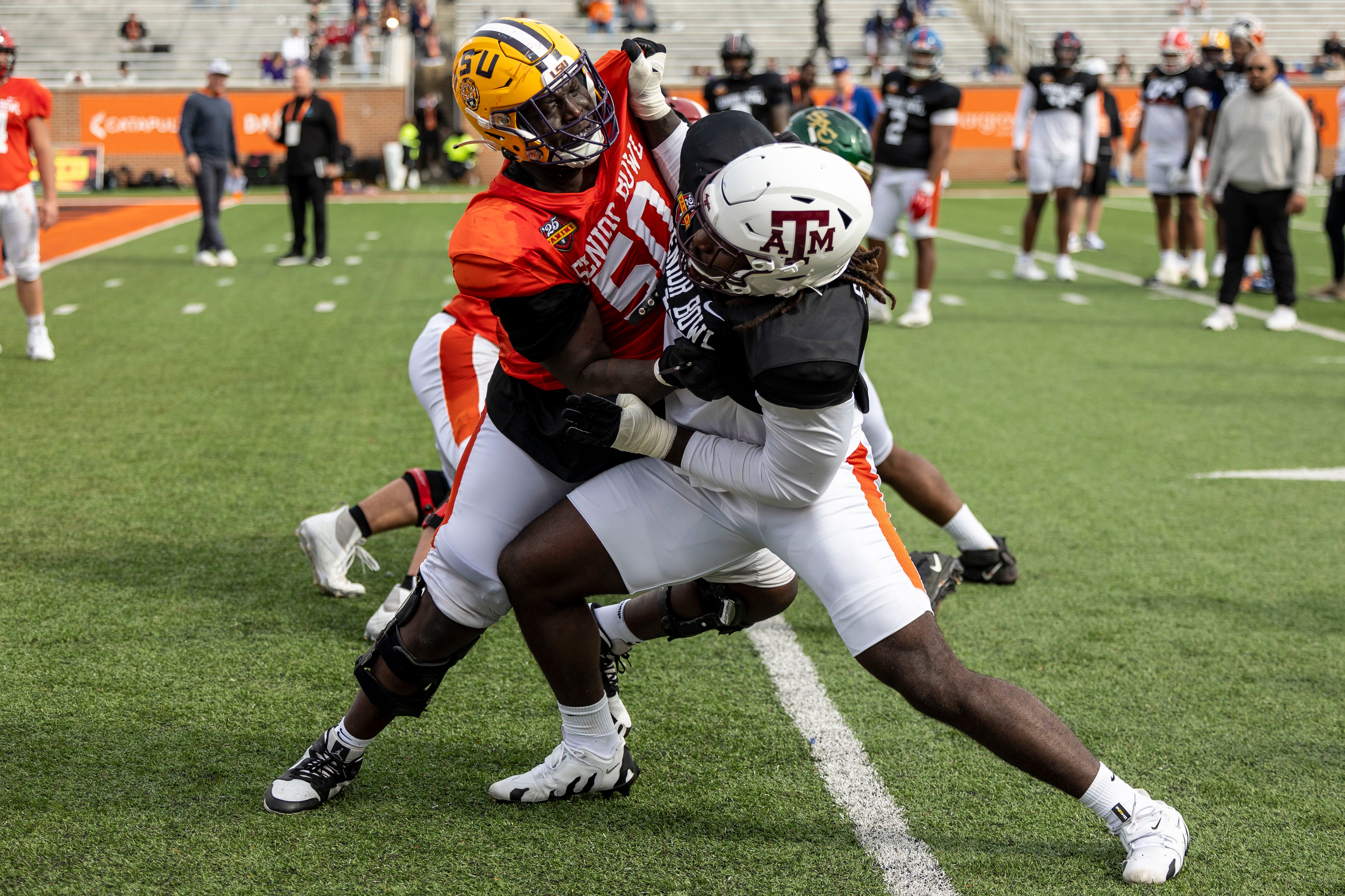 Jan 28, 2025; Mobile, AL, USA; American team offensive lineman Emery Jones of LSU (50) spars with American team defensive lineman Shemar Stewart of Texas A&M (14) during Senior Bowl practice for the American team at Hancock Whitney Stadium.