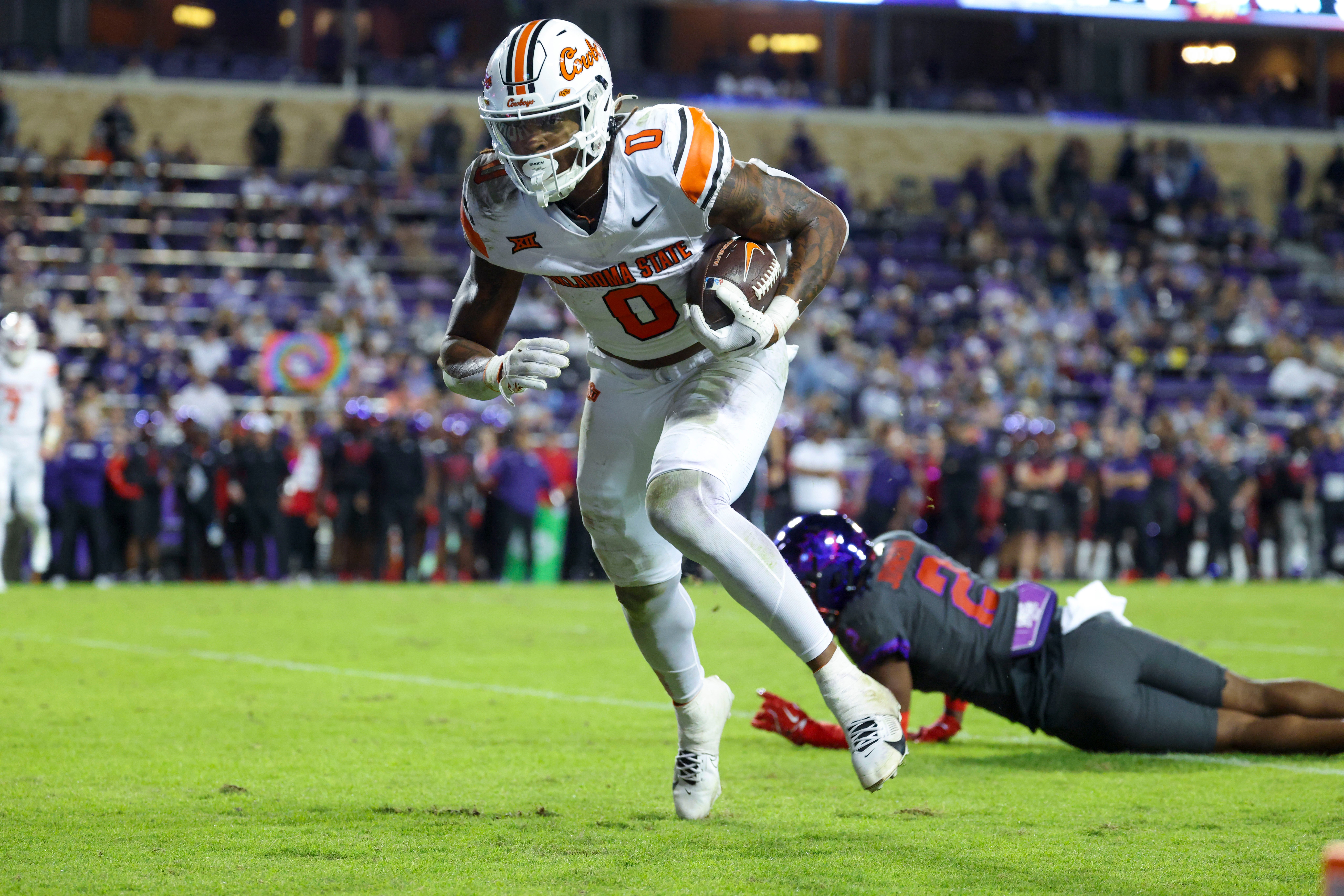 Nov 9, 2024; Fort Worth, Texas, USA; Oklahoma State Cowboys running back Ollie Gordon II (0) scores a touchdown past TCU Horned Frogs safety Jamel Johnson (2) during the second half at Amon G. Carter Stadium.