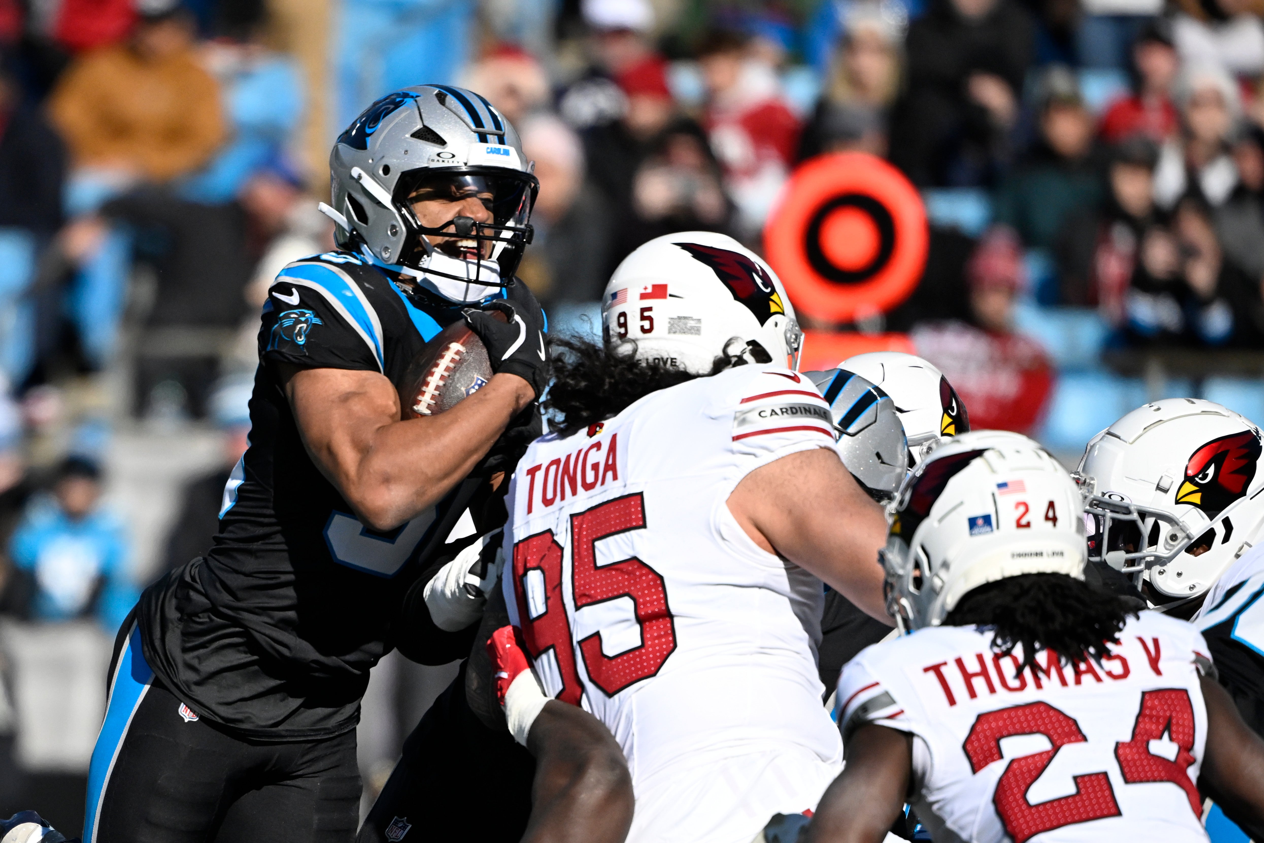 Dec 22, 2024; Charlotte, North Carolina, USA; Carolina Panthers running back Chuba Hubbard (30) gets the first down as Arizona Cardinals defensive tackle Khyiris Tonga (95) defends in the first quarter at Bank of America Stadium.