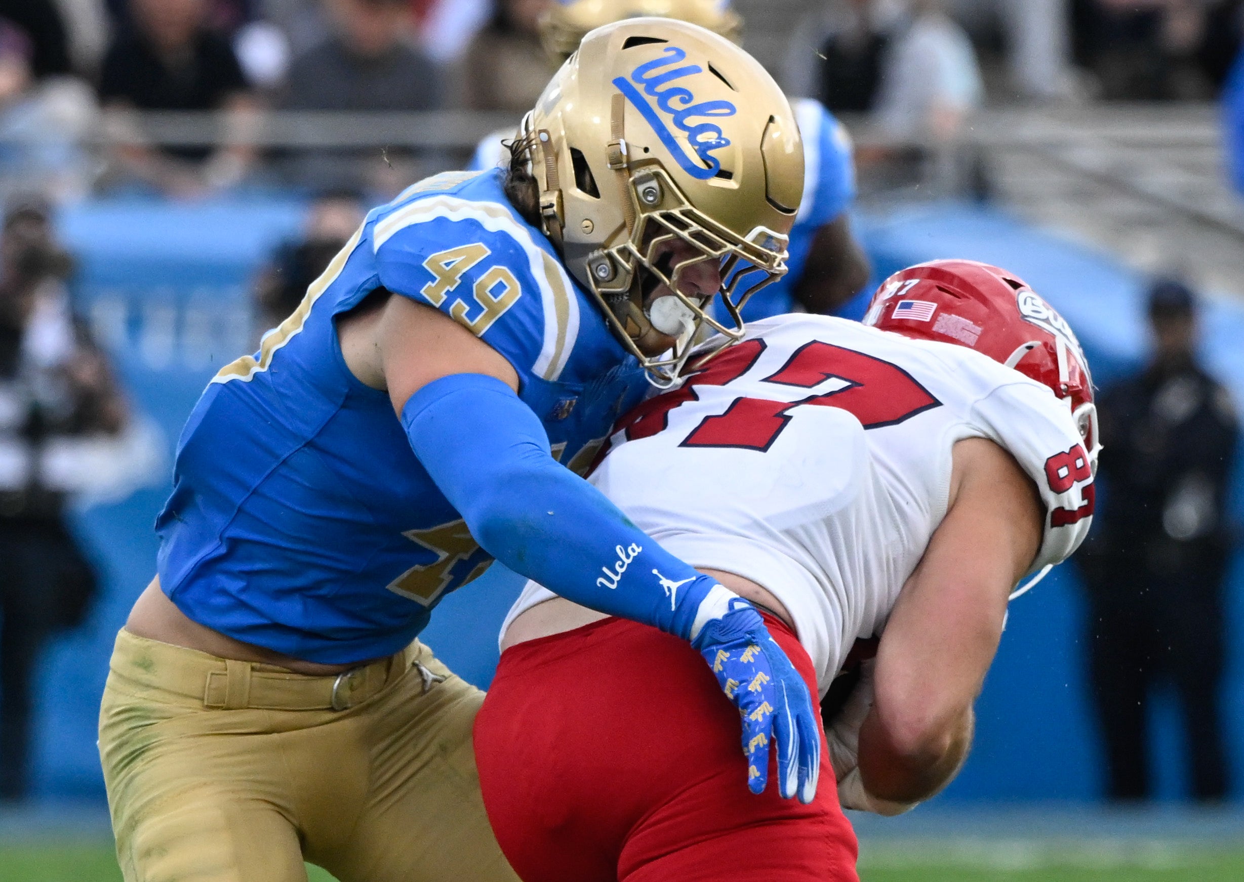 Nov 30, 2024; Pasadena, California, USA; UCLA Bruins linebacker Carson Schwesinger (49) tackles Fresno State Bulldogs tight end Jake Tarwater (87) during the third quarter at Rose Bowl.