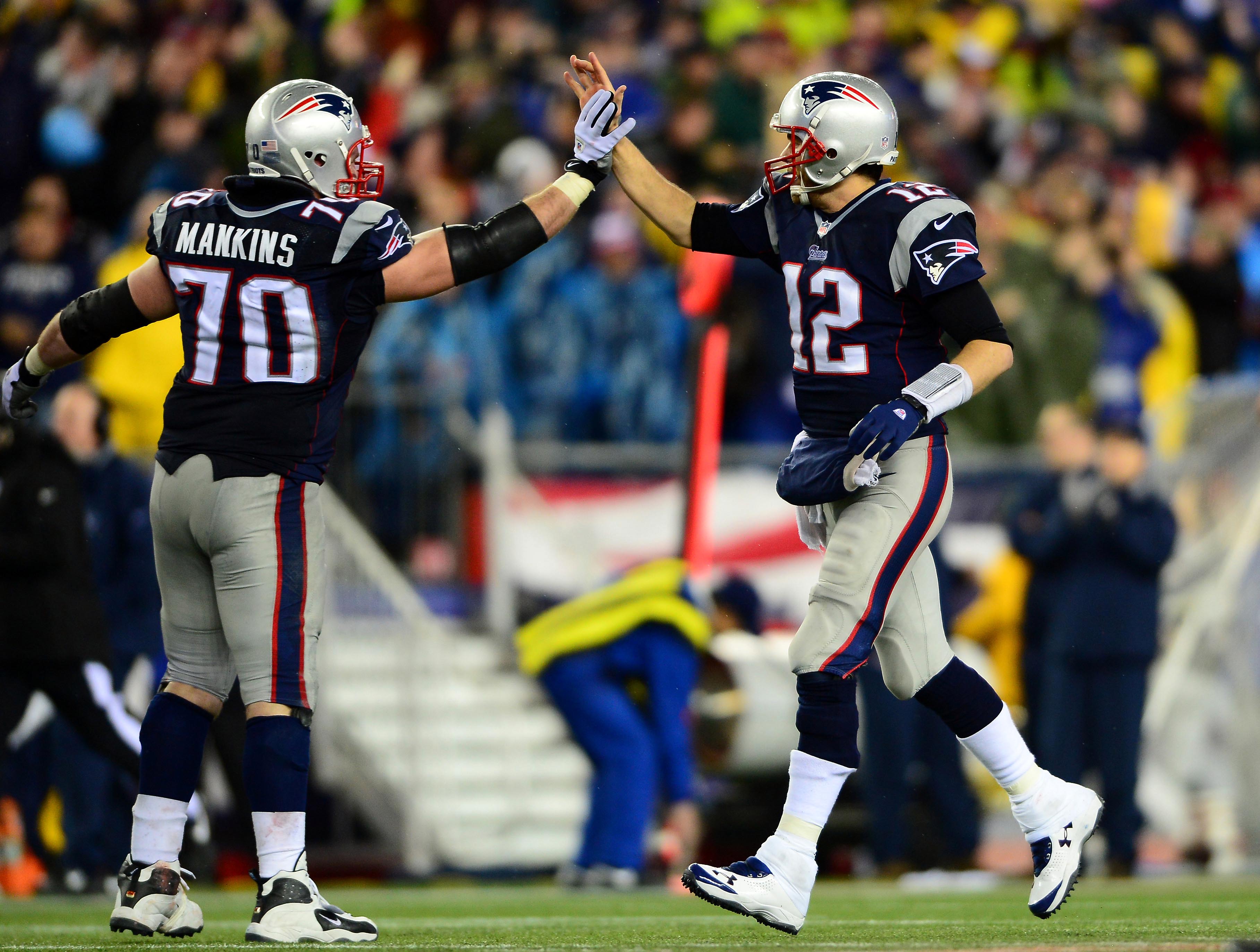 Jan 11, 2014; Foxborough, MA, USA; New England Patriots quarterback Tom Brady (12) celebrates with guard Logan Mankins (70) after a touchdown during the fourth quarter of the 2013 AFC divisional playoff football game against the Indianapolis Colts at Gillette Stadium.