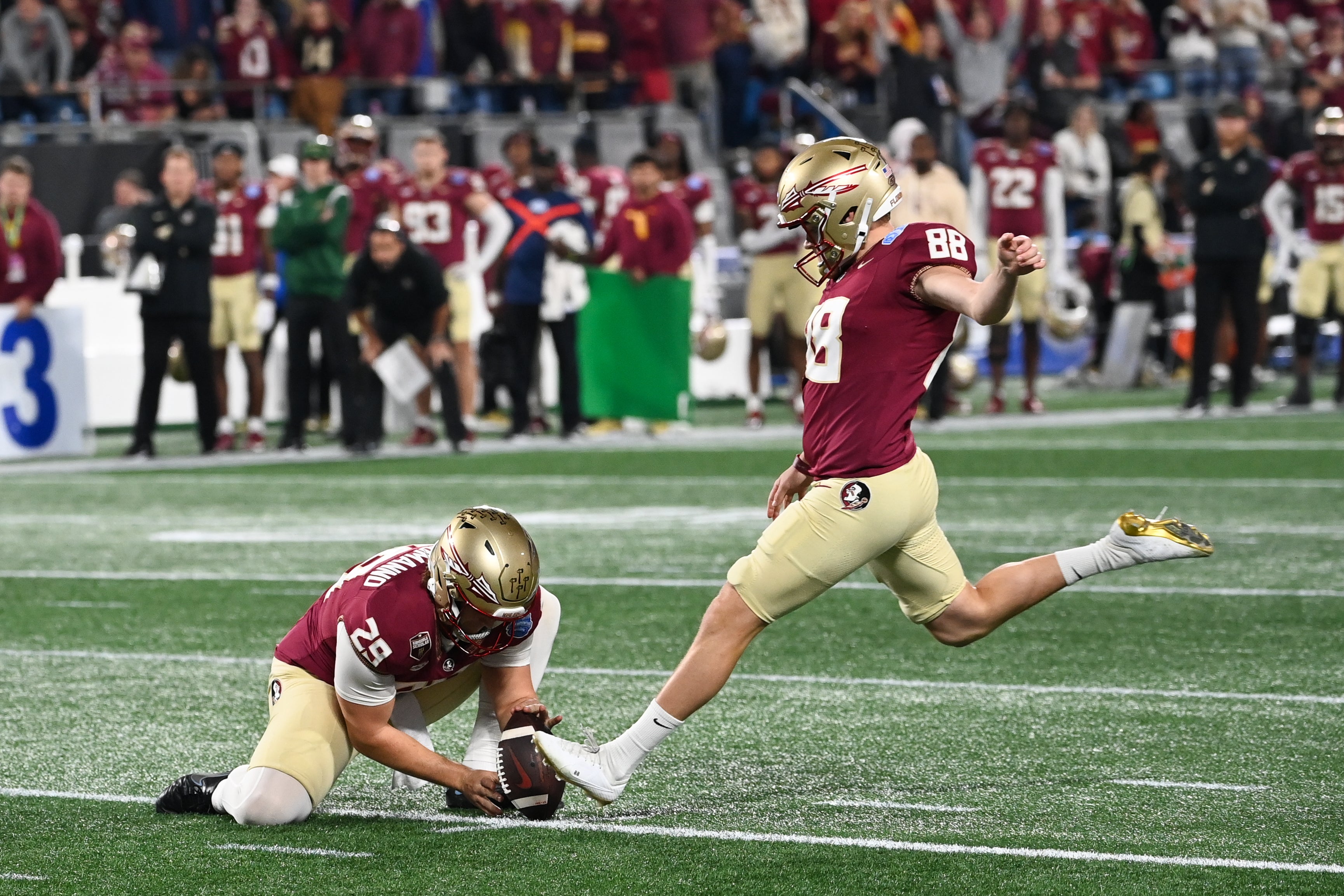 Dec 2, 2023; Charlotte, NC, USA; Florida State Seminoles place kicker Ryan Fitzgerald (88) kicks the ball as punter Alex Mastromanno (29) holds during the second quarter against the Louisville Cardinals at Bank of America Stadium. 