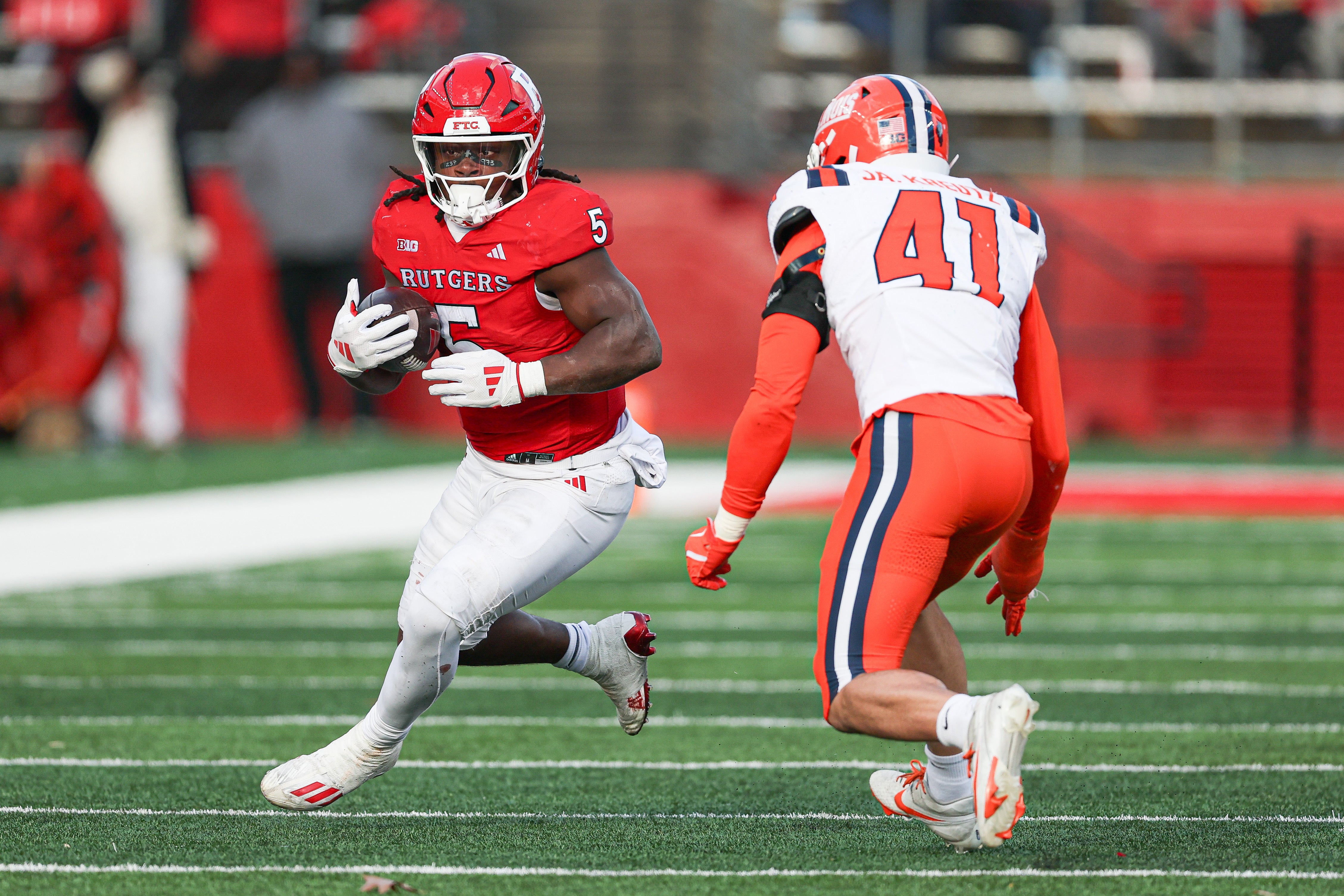 Nov 23, 2024; Piscataway, New Jersey, USA; Rutgers Scarlet Knights running back Kyle Monangai (5) carries the ball as Illinois Fighting Illini linebacker James Kreutz (41) pursues during the second half at SHI Stadium.