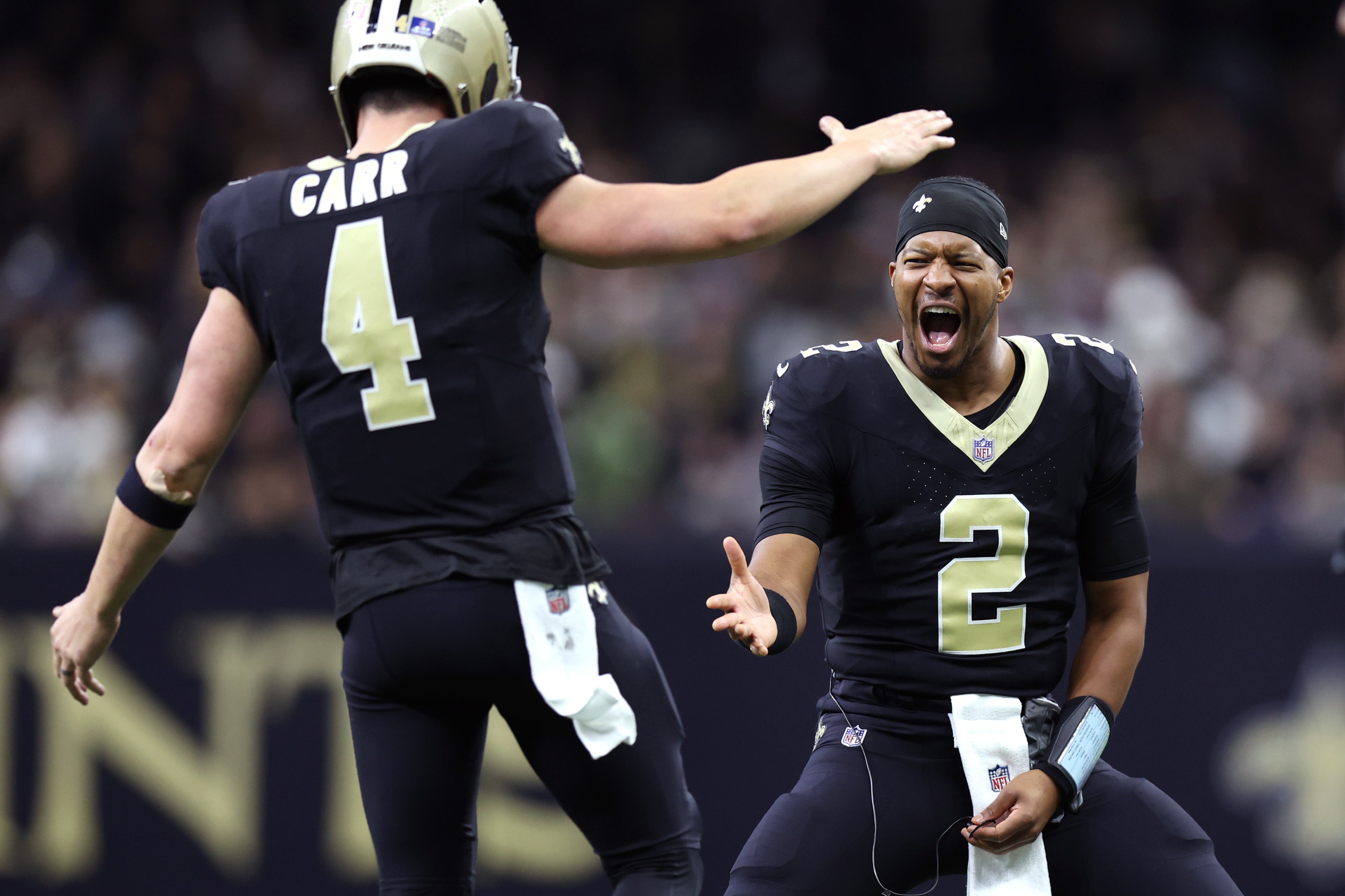 Dec 17, 2023; New Orleans, Louisiana, USA; New Orleans Saints quarterback Derek Carr (4) is congratulated by quarterback Jameis Winston (2) after a touchdown against the New York Giants during the second half at Caesars Superdome.