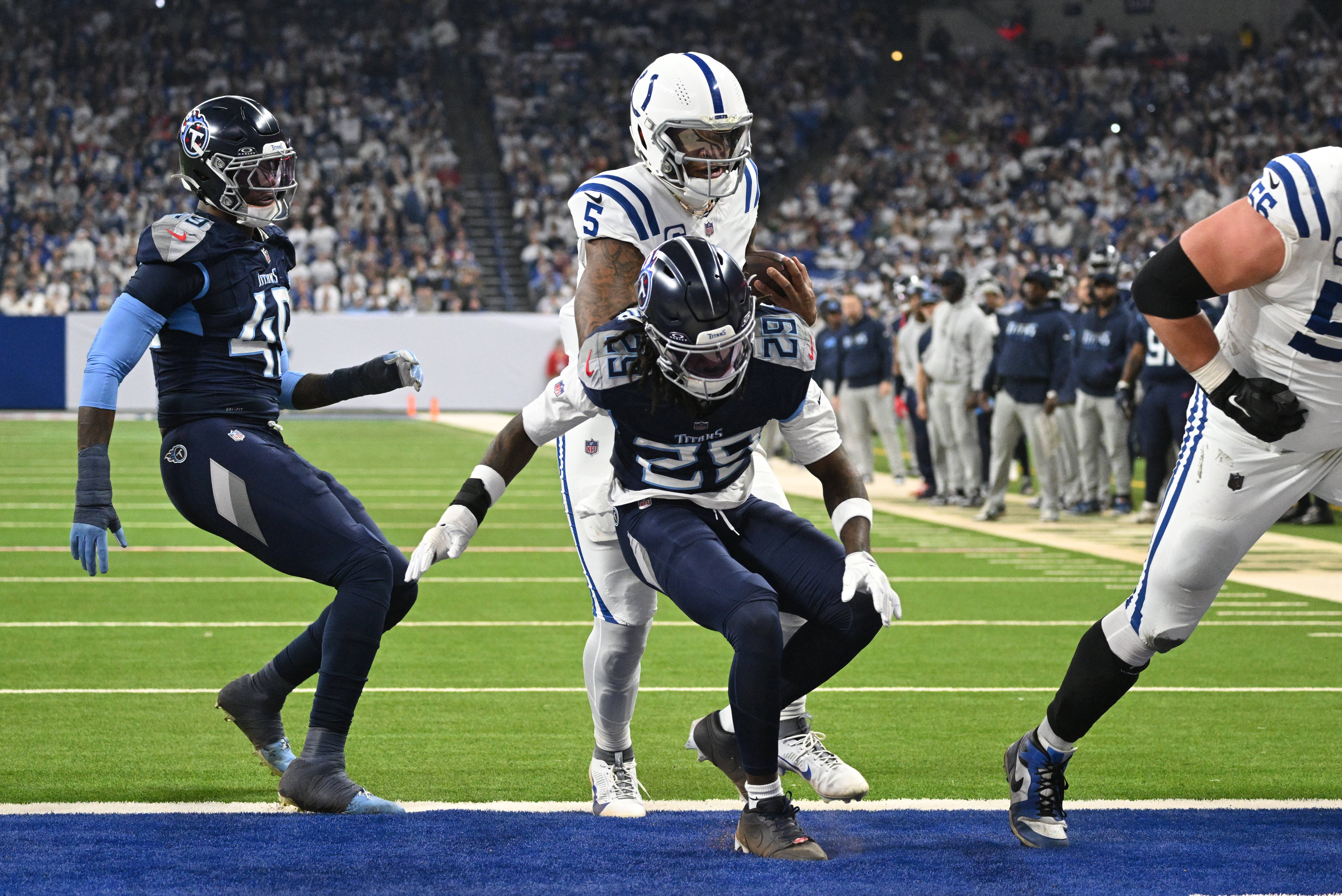 Dec 22, 2024; Indianapolis, Indiana, USA; Indianapolis Colts quarterback Anthony Richardson (5) runs the ball in for a touchdown right behind Tennessee Titans cornerback Jarvis Brownlee Jr. (29) during the second quarter at Lucas Oil Stadium.