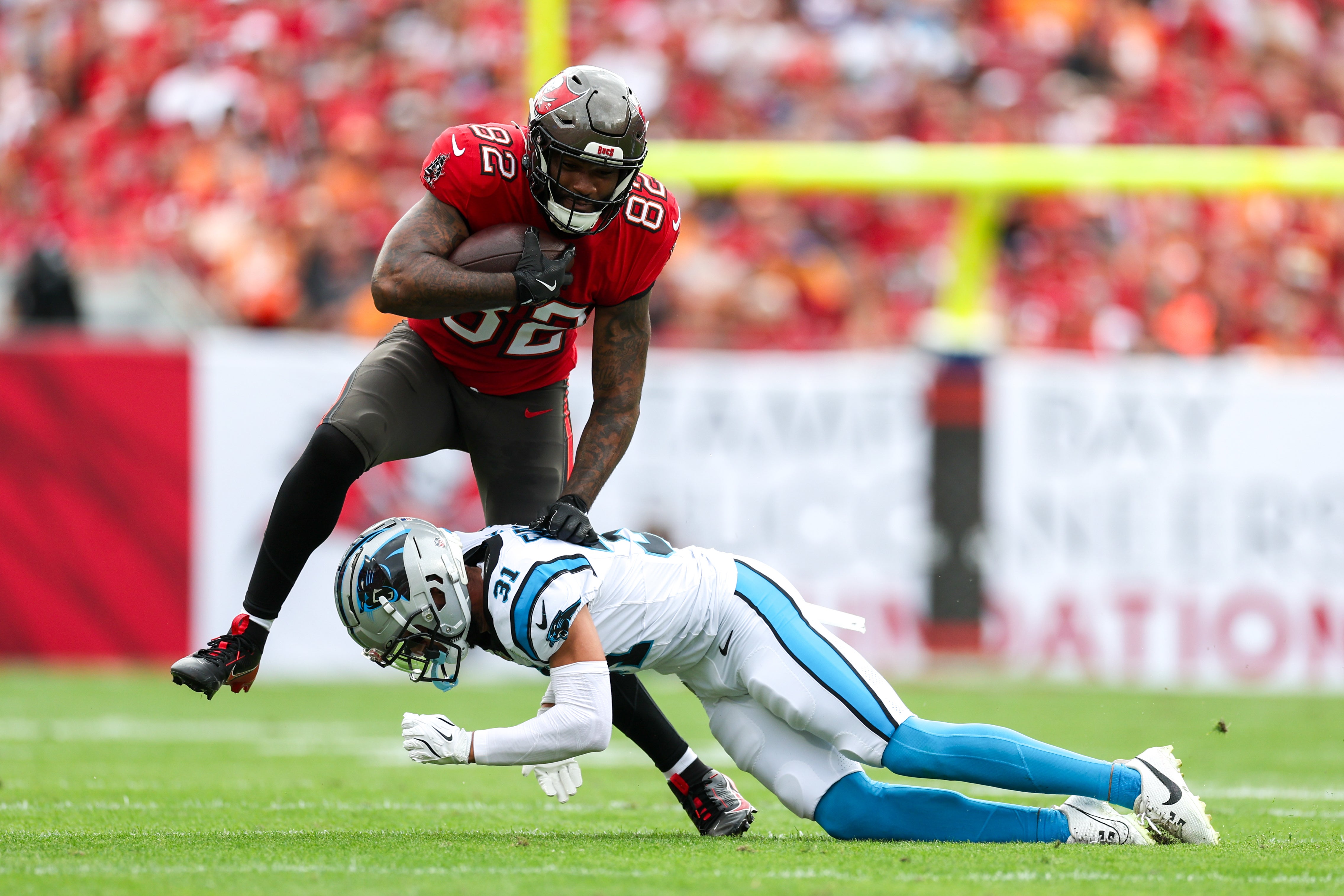 Dec 29, 2024; Tampa, Florida, USA; Tampa Bay Buccaneers tight end Devin Culp (82) holds off Carolina Panthers cornerback Caleb Farley (31) in the first quarter at Raymond James Stadium.