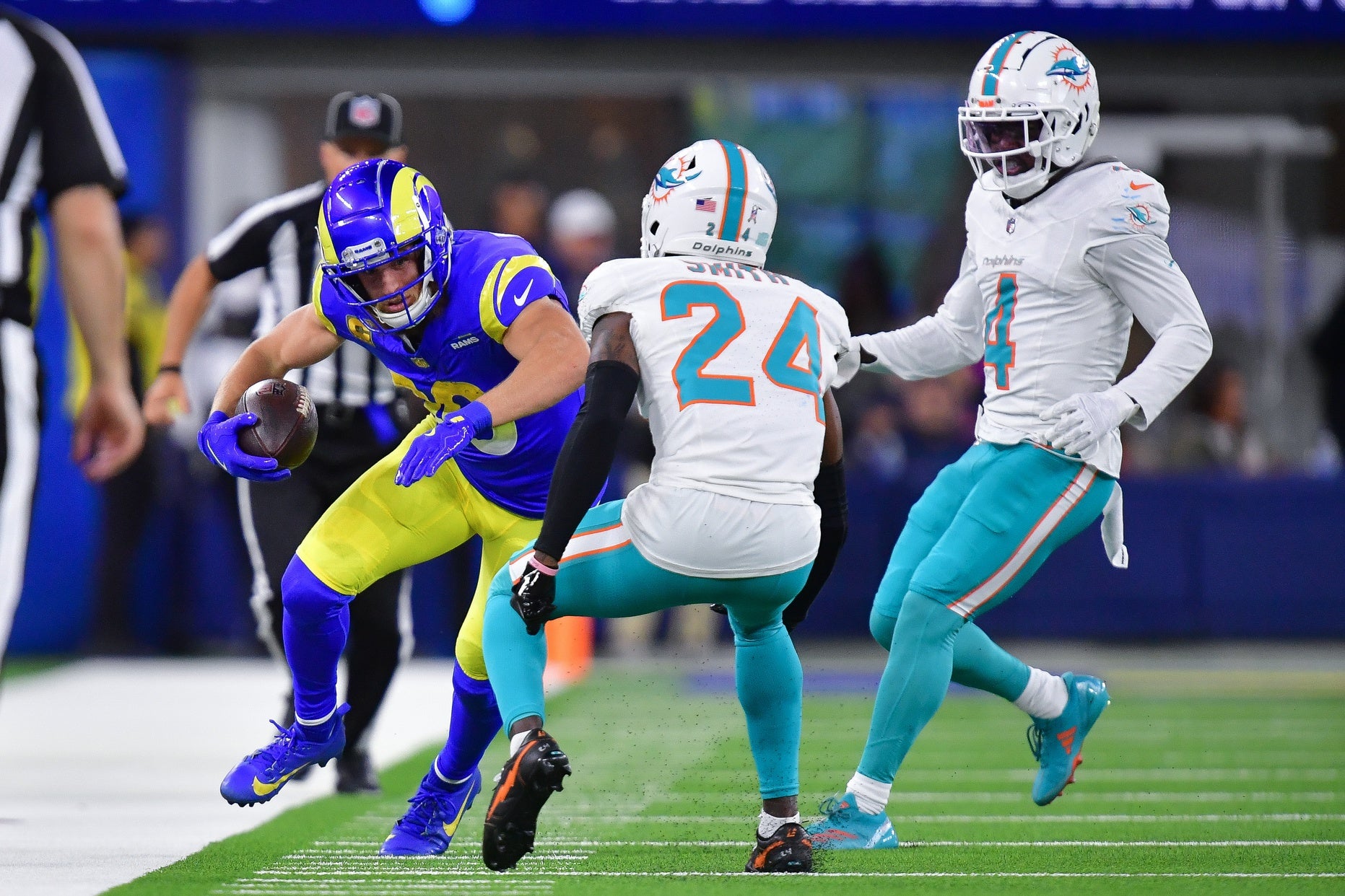 Los Angeles Rams wide receiver Cooper Kupp (10) runs the ball against Miami Dolphins cornerback Cam Smith (24) and cornerback Kader Kohou (4) during the second half at SoFi Stadium.