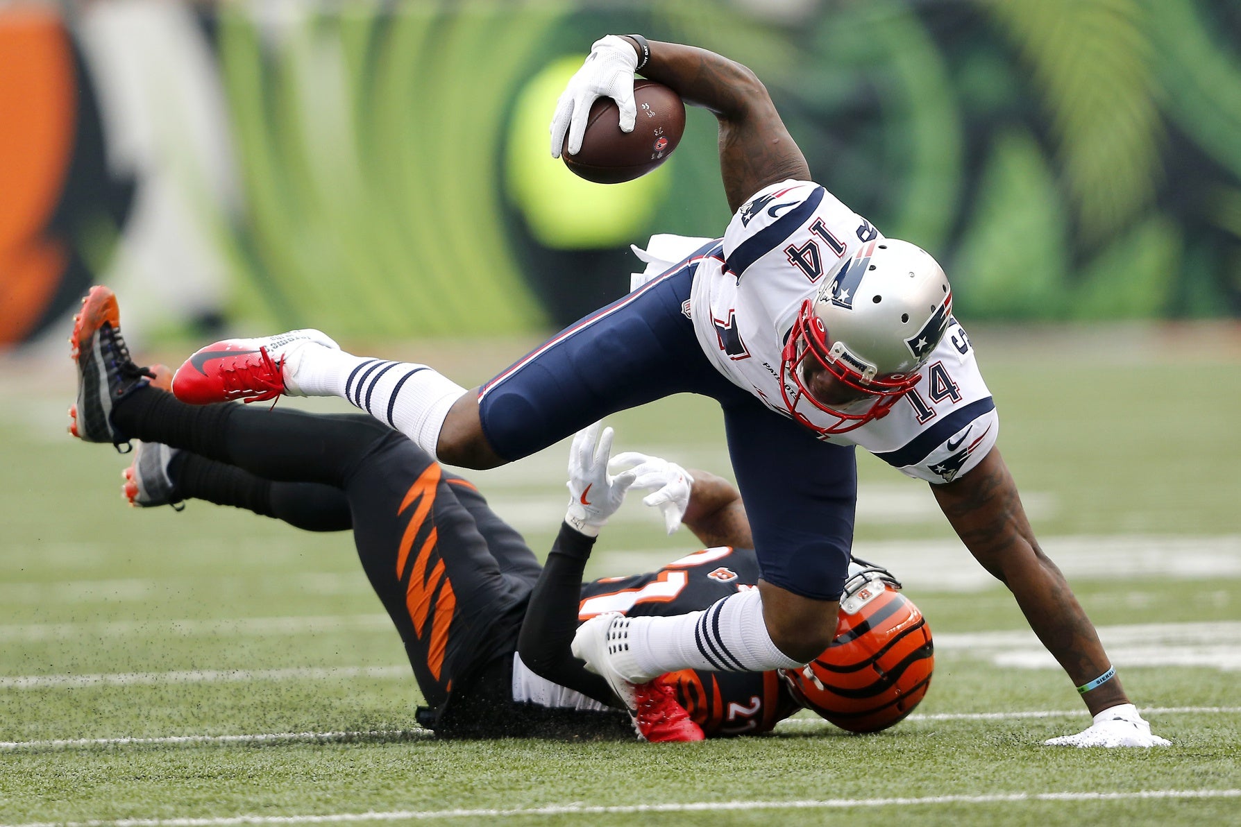 New England Patriots wide receiver Mohamed Sanu (14) runs after catch as Cincinnati Bengals defensive back Darqueze Dennard (21) makes the tackle at Paul Brown Stadium.