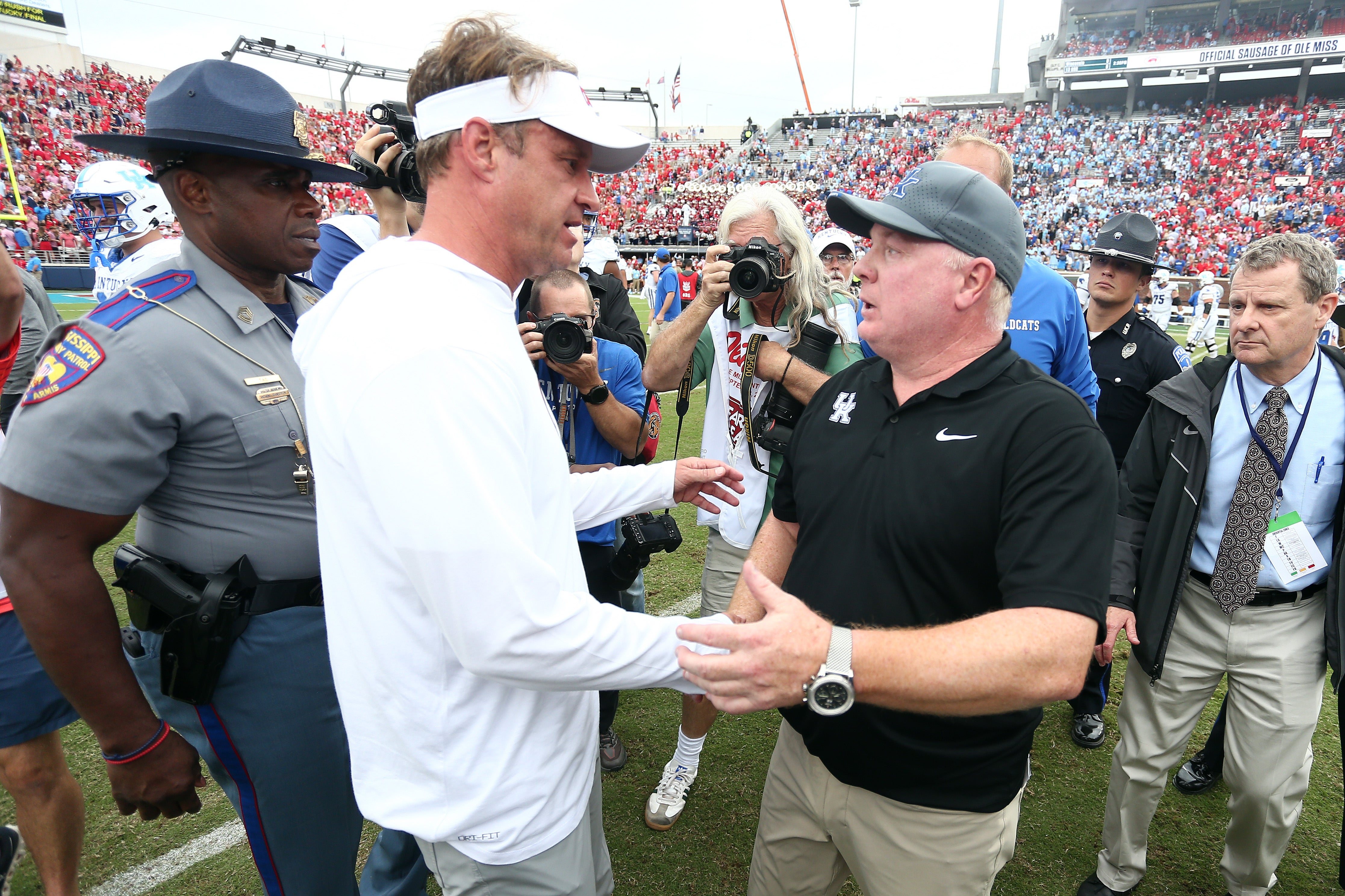 Sep 28, 2024; Oxford, Mississippi, USA; Mississippi Rebels head coach Lane Kiffin (left) and Kentucky Wildcats head coach Mark Stoops (right) shake hands after the game at Vaught-Hemingway Stadium.