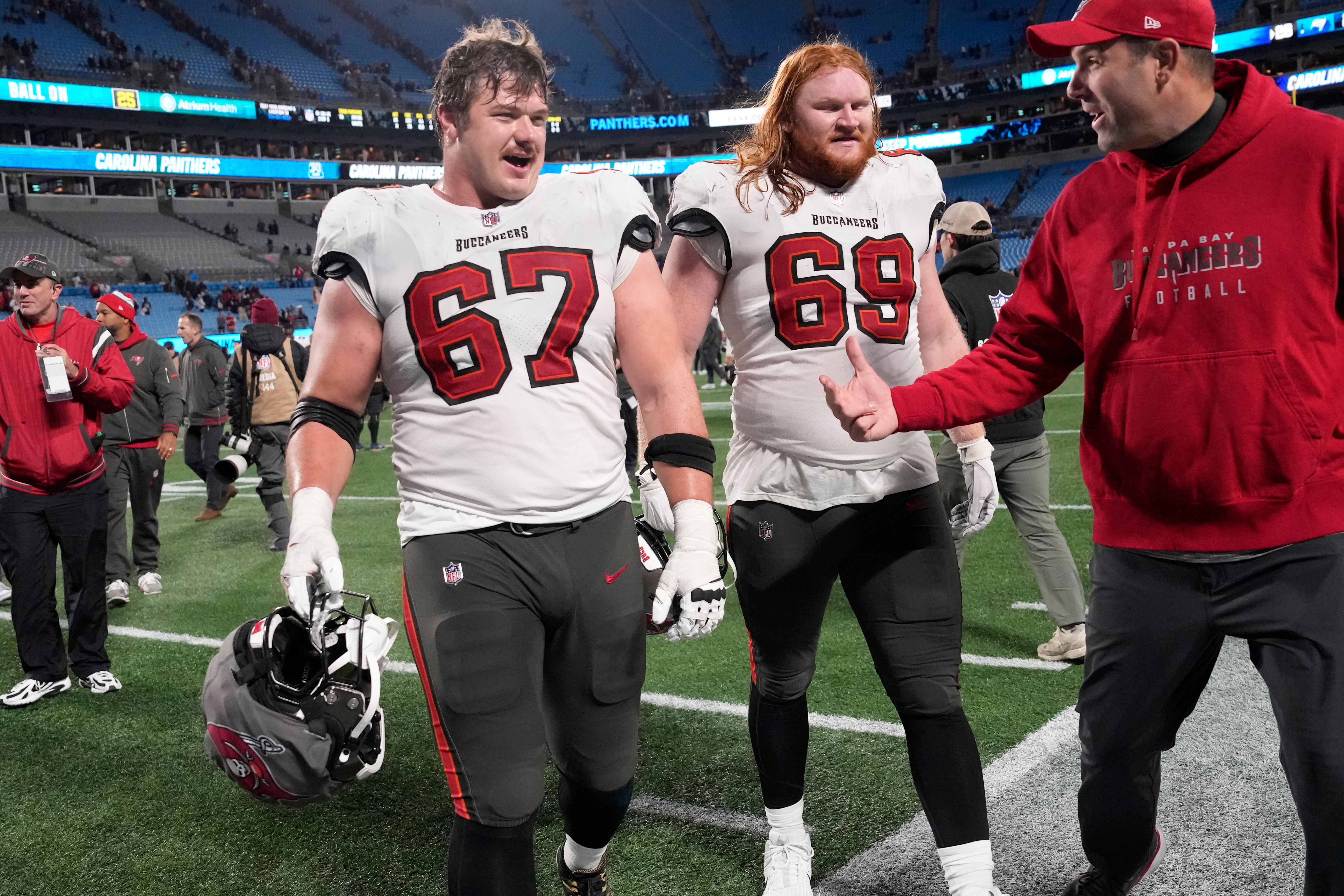 Dec 1, 2024; Charlotte, North Carolina, USA; Tampa Bay Buccaneers offensive tackle Luke Goedeke (67) and guard Cody Mauch (69) leave the field after the game at Bank of America Stadium.