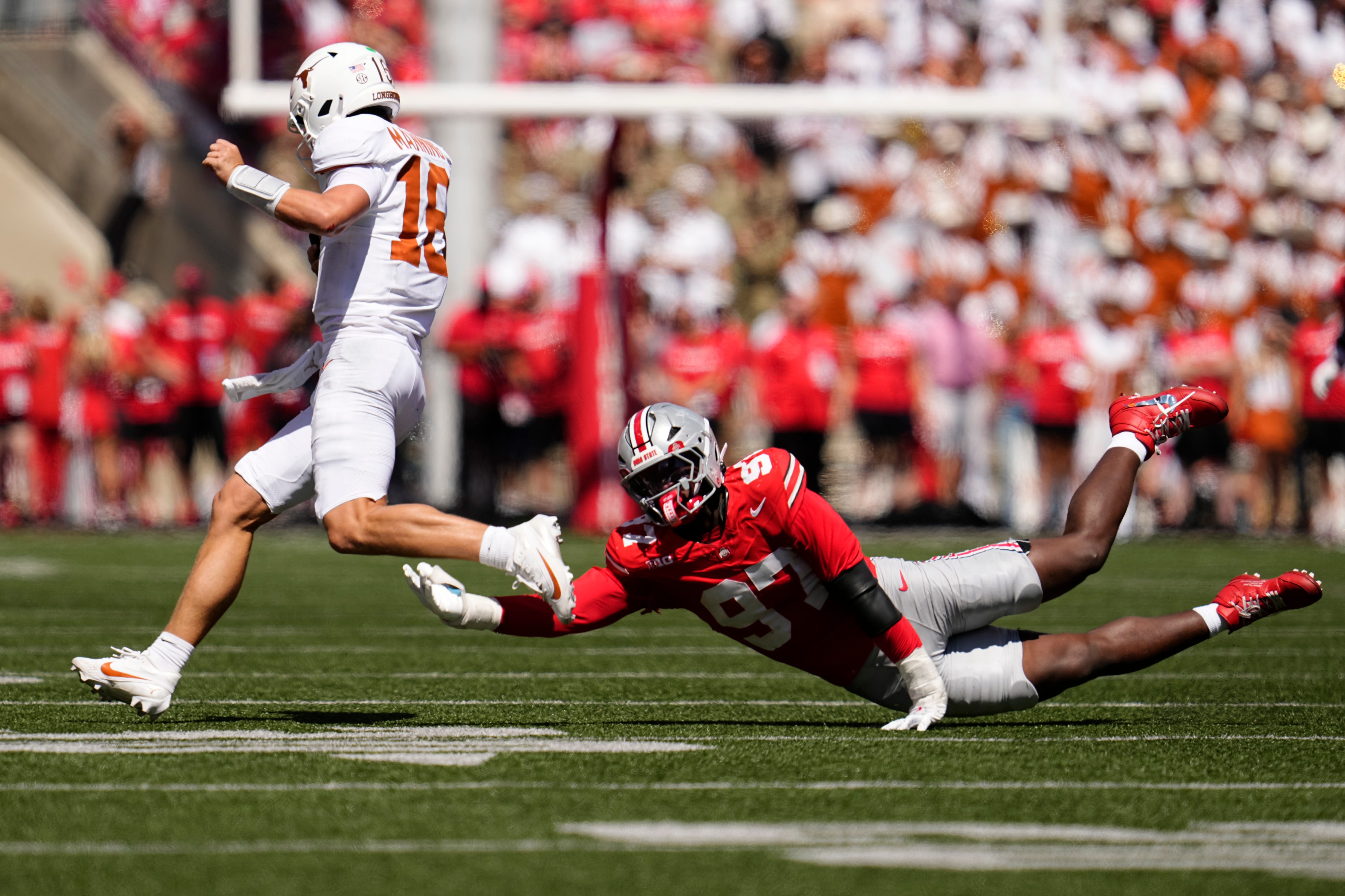 Texas Longhorns quarterback Arch Manning (16) runs around Ohio State Buckeyes defensive end Kenyatta Jackson Jr. (97) during the second half of the NCAA football game at Ohio Stadium on Aug. 30, 2025. Ohio State won 14-7.