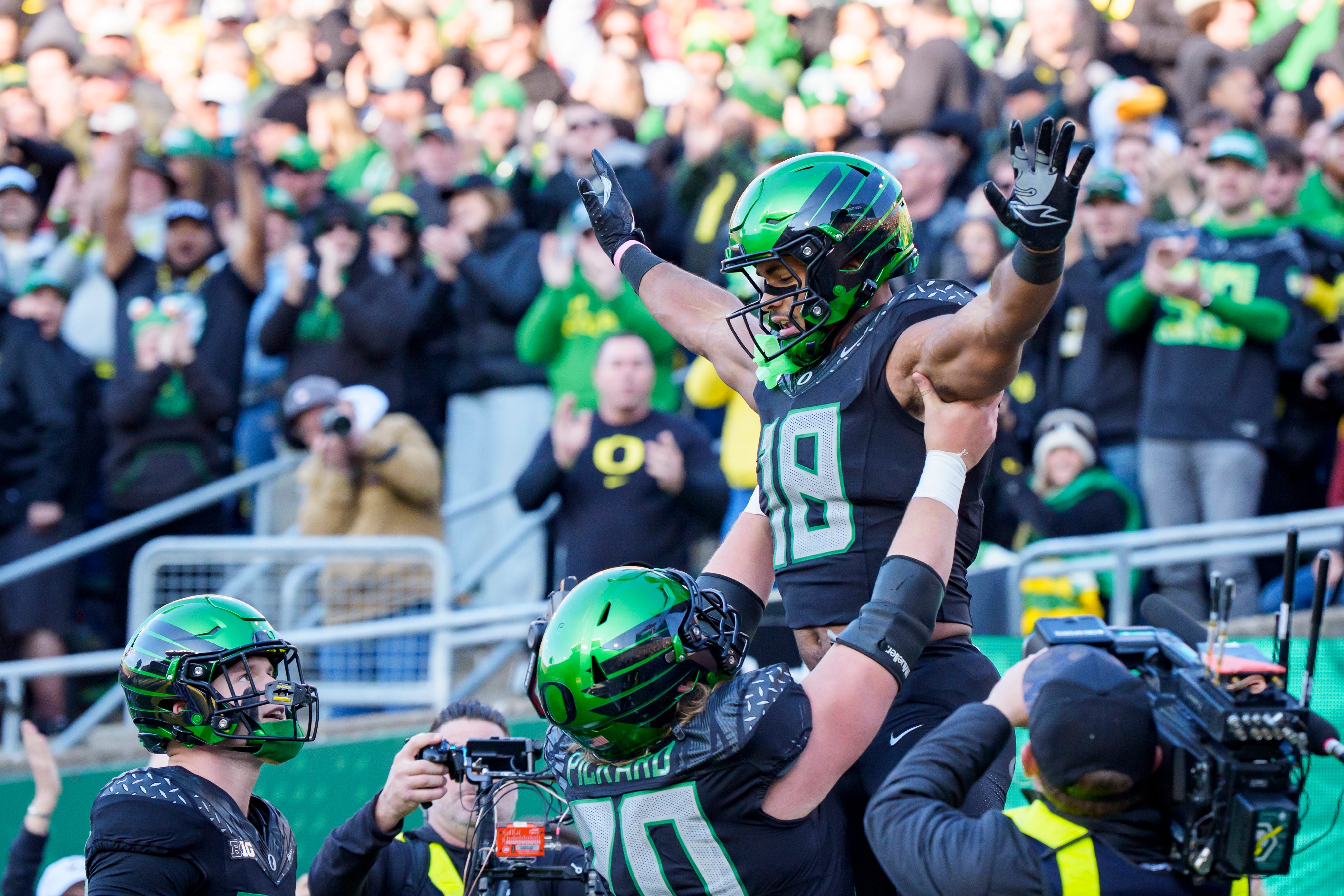 Oregon offensive lineman Charlie Pickard hoists tight end Kenyon Sadiq into the air to celebrate a touchdown as the Oregon Ducks host the USC Trojans on Nov. 22, 2025, at Autzen Stadium in Eugene, Oregon.