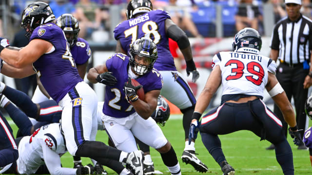 Baltimore Ravens running back J.K. Dobbins (27) takes a handoff from  quarterback Lamar Jackson …