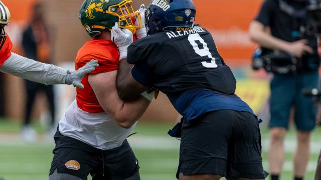 Jan 30, 2025; Mobile, AL, USA; National team offensive lineman Grey Zabel of North Dakota State (77) works against National team defensive lineman Darius Alexander of Toledo (9) during Senior Bowl practice for the National team at Hancock Whitney Stadium.