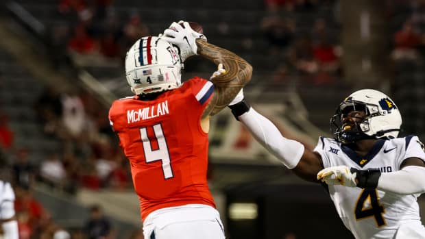 Oct 26, 2024; Tucson, Arizona, USA; Arizona Wildcats wide receiver Tetairoa McMillan (4) catches a long pass while West Virginia Mountaineers linebacker Trey Lathan (4) fails to defend against him during the fourth quarter at Arizona Stadium.