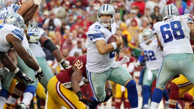 Dallas Cowboys quarterback Tony Romo (9) scrambles from Washington Redskins outside linebacker Rob Jackson (50) in the fourth quarter at FedEx Field. Romo was injured on the play and is out for the season. The Cowboys won 24-23.
