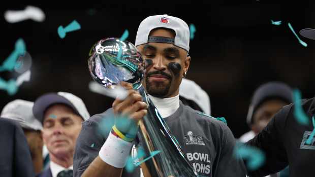 Philadelphia Eagles quarterback Jalen Hurts holds the Lombardi Trophy during the championship trophy presentation after the Eagles' game against the Kansas City Chiefs in Super Bowl LIX at Caesars Superdome.