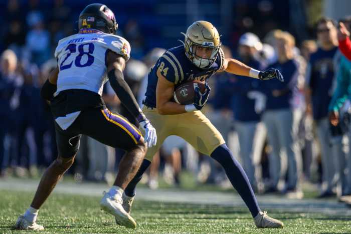 Nov 18, 2023; Annapolis, Maryland, USA; Navy Midshipmen wide receiver Regis Velez (84) runs the ball against East Carolina Pirates defensive back Shavon Revel (28) during the second quarter at Navy-Marine Corps Memorial Stadium.