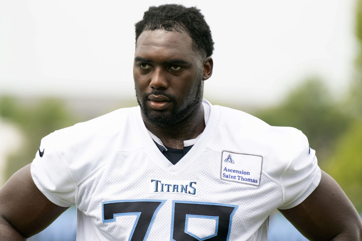 Tennessee Titans offensive lineman Nicholas Petit-Frere (78) runs onto the  field with a member of the military during a Salute to Service pregame  ceremony before an NFL football game between the Denver