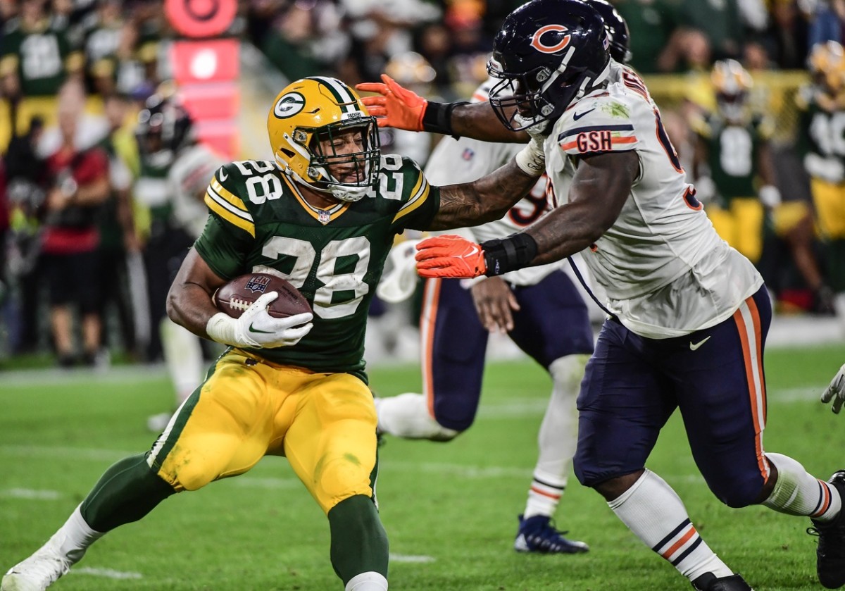 Sep 18, 2022; Green Bay, Wisconsin, USA; Green Bay Packers running back A.J. Dillon (28) tries to break a tackle by Chicago Bears defensive tackle Justin Jones (93) in the fourth quarter at Lambeau Field. Mandatory Credit: Benny Sieu-USA TODAY Sports