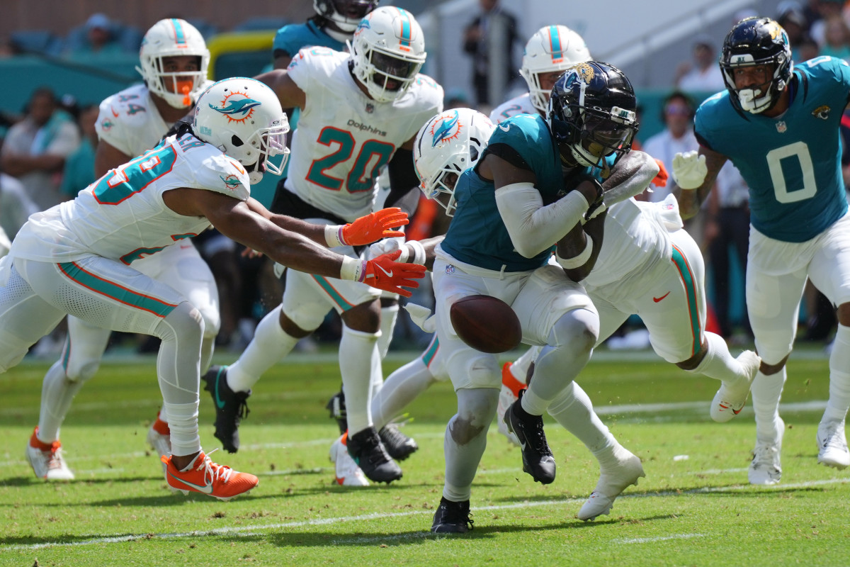 Sep 8, 2024; Miami Gardens, Florida, USA; Miami Dolphins safety Jevon Holland (8) punches the ball away from Jacksonville Jaguars running back Travis Etienne Jr. (1) causing a fumble that was recovered by the Dolphins in the end zone during the third quarter at Hard Rock Stadium.