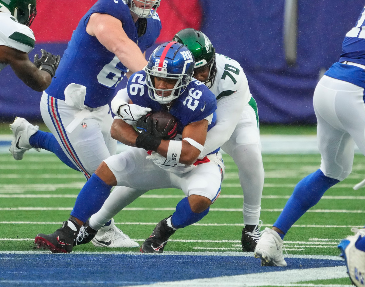 New York Jets defensive tackle Quinton Jefferson (70) stops New York Giants running back Saquon Barkley (26) in the first half at MetLife Stadium.