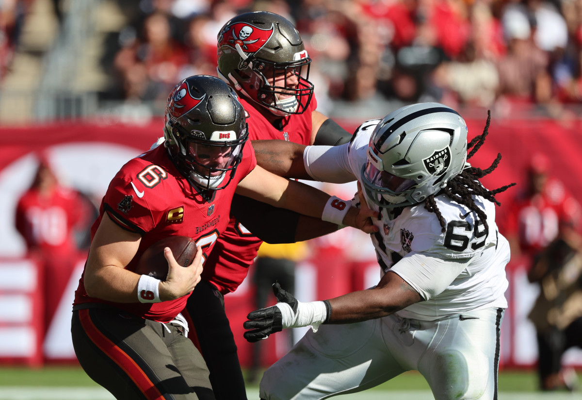 Dec 8, 2024; Tampa, Florida, USA; Tampa Bay Buccaneers quarterback Baker Mayfield (6) stiff arms Las Vegas Raiders defensive tackle Adam Butler (69) during the second quarter at Raymond James Stadium.