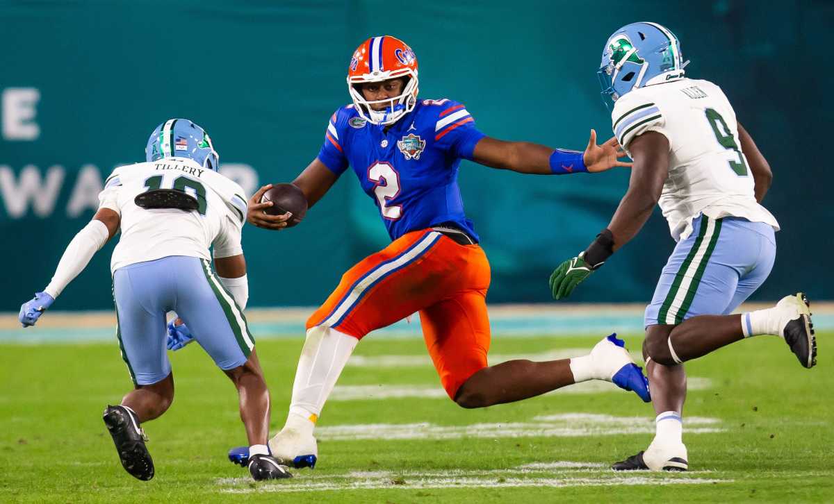 Florida Gators quarterback DJ Lagway (2) eludes Tulane Green Wave defensive back Lu Tillery (10) and Tulane Green Wave linebacker Terrell Allen (9) during the second half at Raymond James Stadium in Tampa, FL on Friday, December 20, 2024 in the 2024 Union Home Mortgage Gasparilla Bowl. The Gators defeated Tulane 33-8.