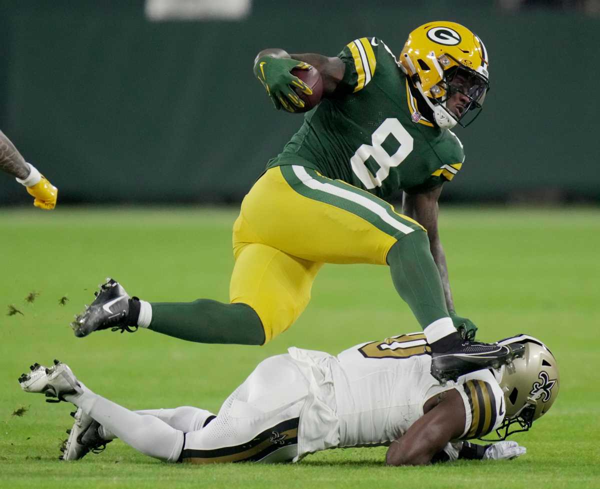 Green Bay Packers running back Josh Jacobs (8) is tackled by New Orleans Saints safety Ugo Amadi (0) during the first quarter of their game Monday, December 23, 2024 at Lambeau Field in Green Bay, Wisconsin.