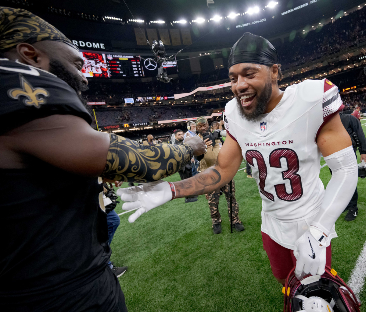 Dec 15, 2024; New Orleans, Louisiana, USA; New Orleans Saints linebacker Demario Davis (56) greets former teammate Washington Commanders cornerback Marshon Lattimore (23) at the end of the game at Caesars Superdome.