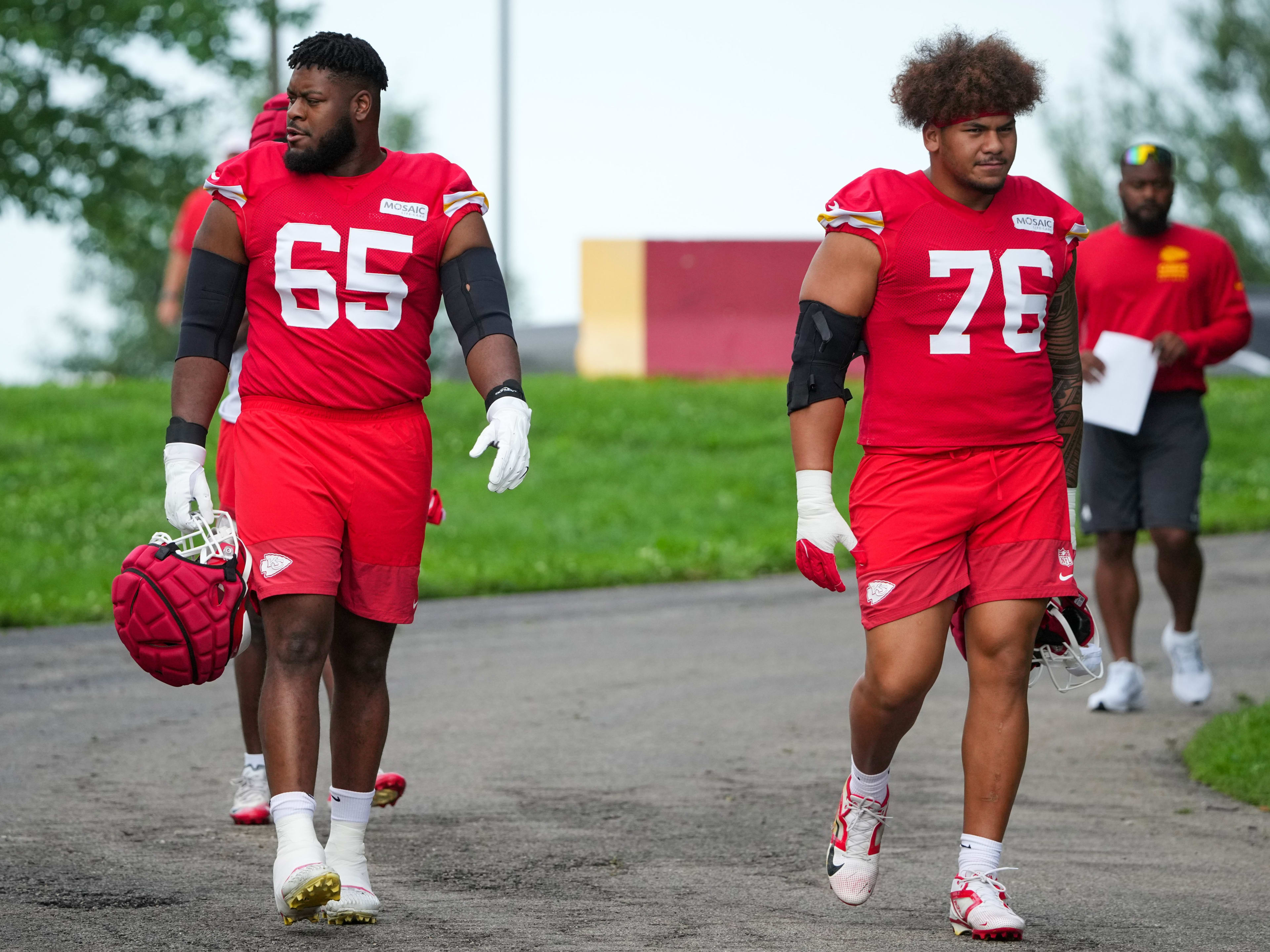 Jul 22, 2025; St. Joseph, MO, USA; Kansas City Chiefs guard Trey Smith (65) and offensive tackle Kingsley Suamataia (76) walk down the hill to the practice fields during training camp at Missouri Western State University. Mandatory Credit: Denny Medley-Imagn Images