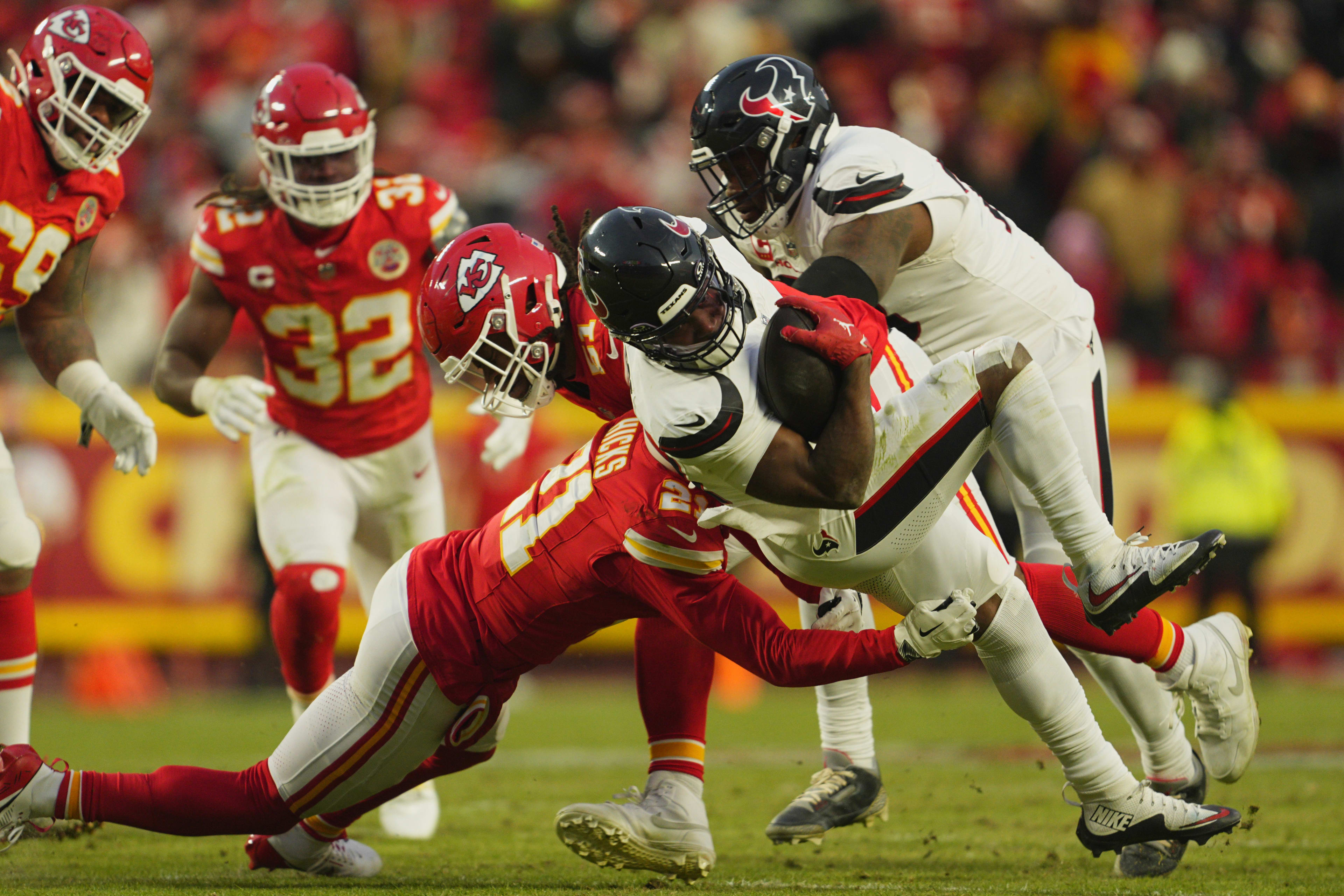 Jan 18, 2025; Kansas City, Missouri, USA; Houston Texans running back Dameon Pierce (31) runs the ball against Kansas City Chiefs safety Jaden Hicks (21) during the third quarter of a 2025 AFC divisional round game at GEHA Field at Arrowhead Stadium. 
