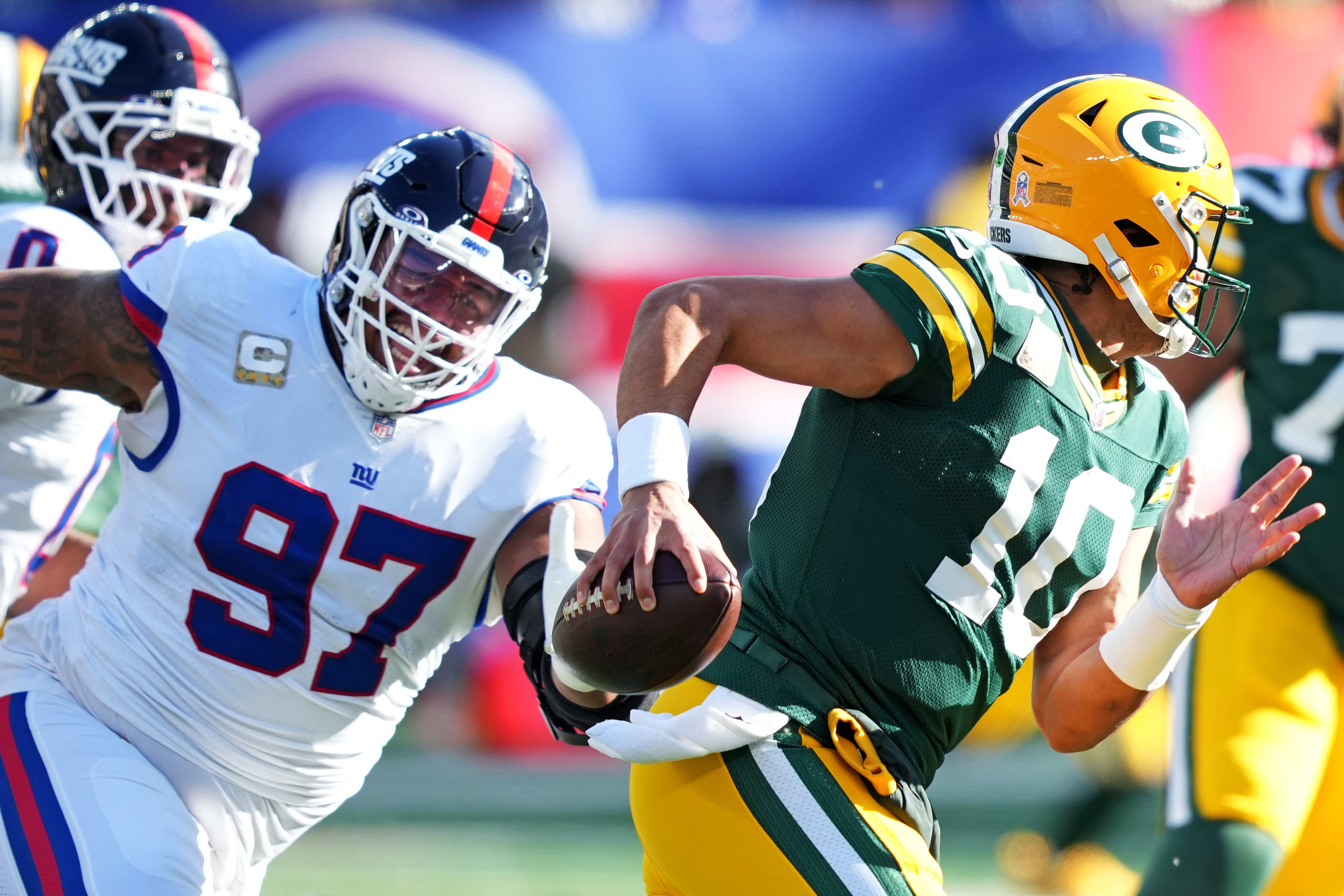 Nov 16, 2025; East Rutherford, New Jersey, USA; Green Bay Packers quarterback Jordan Love (10) scrambles away from New York Giants defensive tackle Dexter Lawrence II (97) during the first quarter at MetLife Stadium.