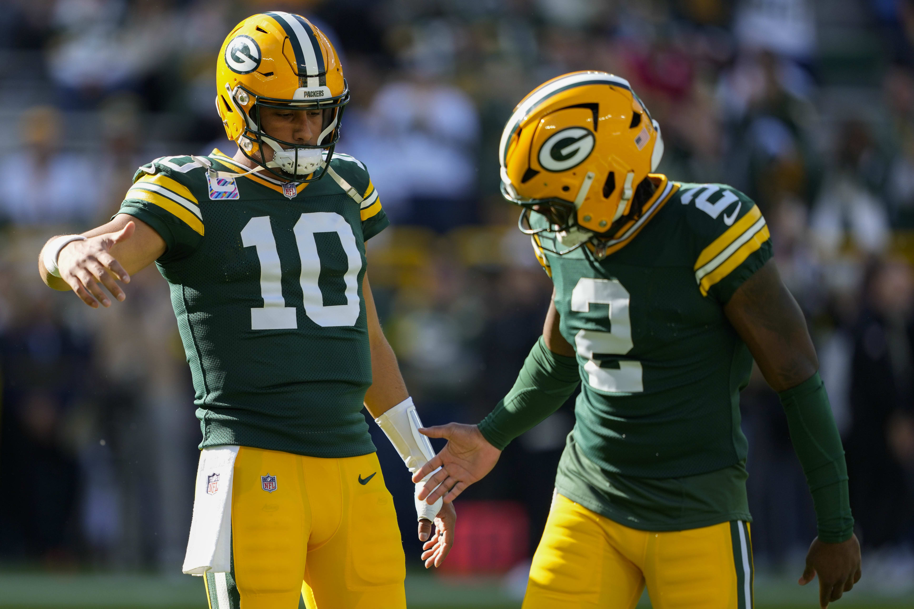 Oct 12, 2025; Green Bay, Wisconsin, USA; Green Bay Packers quarterback Jordan Love (10) greets quarterback Malik Willis (2) during warmups prior to the game against the Cincinnati Bengals at Lambeau Field.