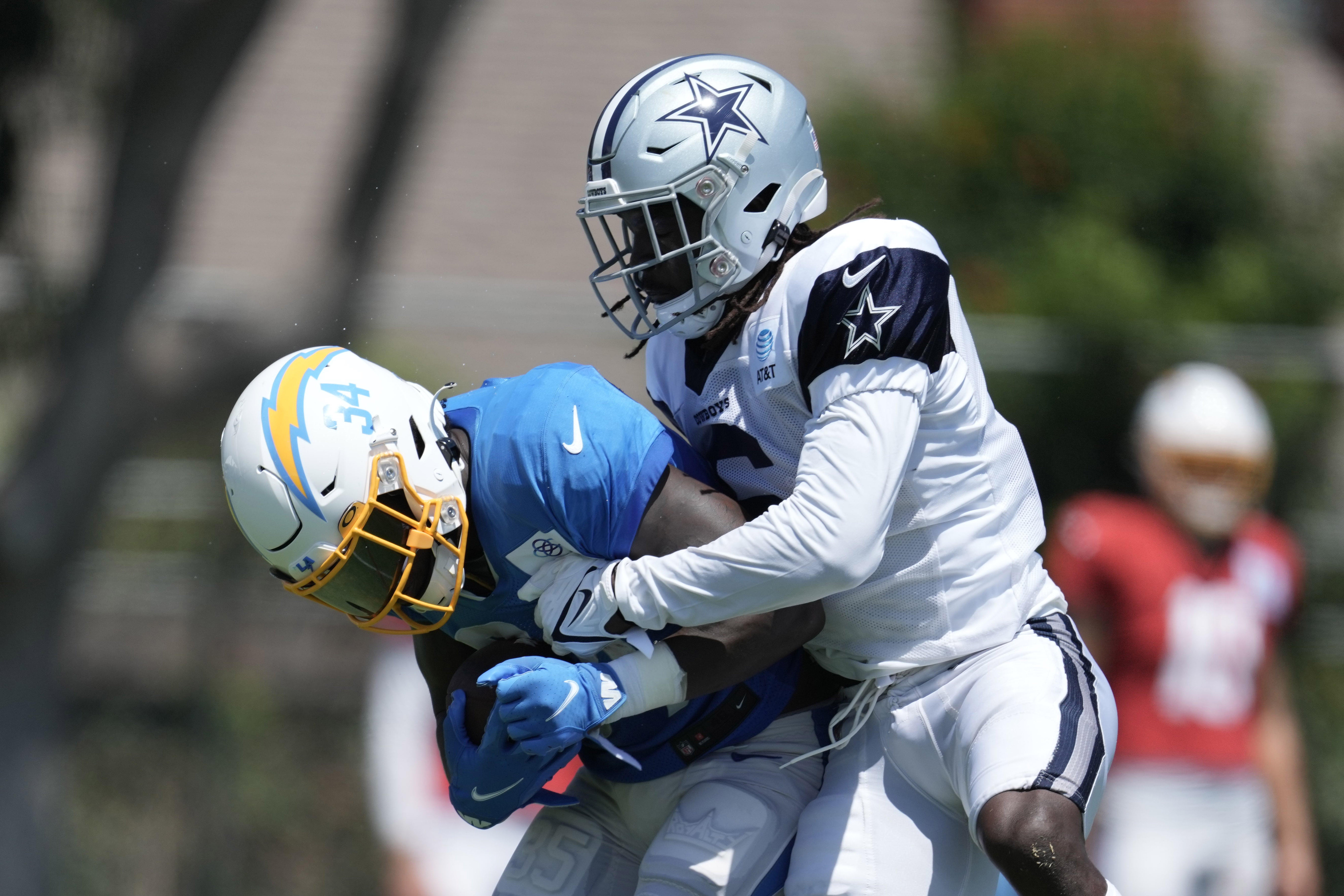 Aug 17, 2022; Costa Mesa, CA, USA; Los Angeles Chargers running back Larry Rountree III (34) is tackled by Dallas Cowboys safety Donovan Wilson (6) during joint practice at Jack Hammett Sports Complex. Mandatory Credit: Kirby Lee-USA TODAY Sports