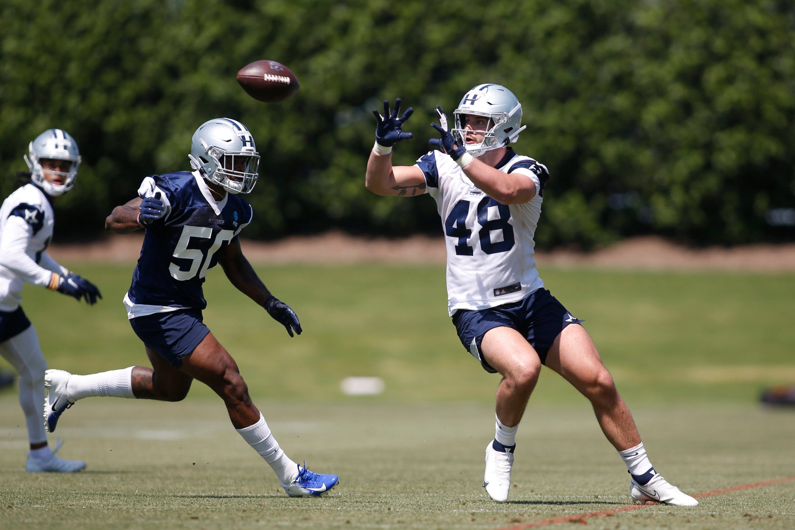 May 14, 2022; Frisco, Texas, USA; Dallas Cowboys tight end Jake Ferguson (48) catches a pass against linebacker Devin Harper (50) during practice at the Ford Center at the Star Training Facility in Frisco, Texas.   Mandatory Credit: Tim Heitman-USA TODAY Sports