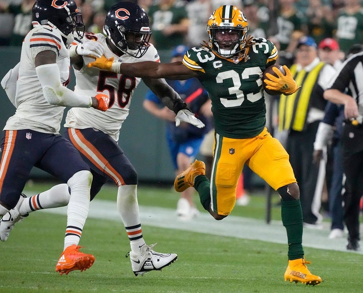 Green Bay Packers running back Aaron Jones (33) runs for a long gain as he stiff arms Chicago Bears linebacker Roquan Smith (58) during the third quarter of their game on Sunday, Sept. 18, 2022 at Lambeau Field in Green Bay. Packers Bears Packers19 2597