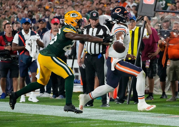 Chicago Bears quarterback Justin Fields (1) reaches for a first down as Green Bay Packers safety Darnell Savage (26) chases him down during the fourth quarter of their game on Sunday, Sept. 18, 2022 at Lambeau Field in Green Bay.