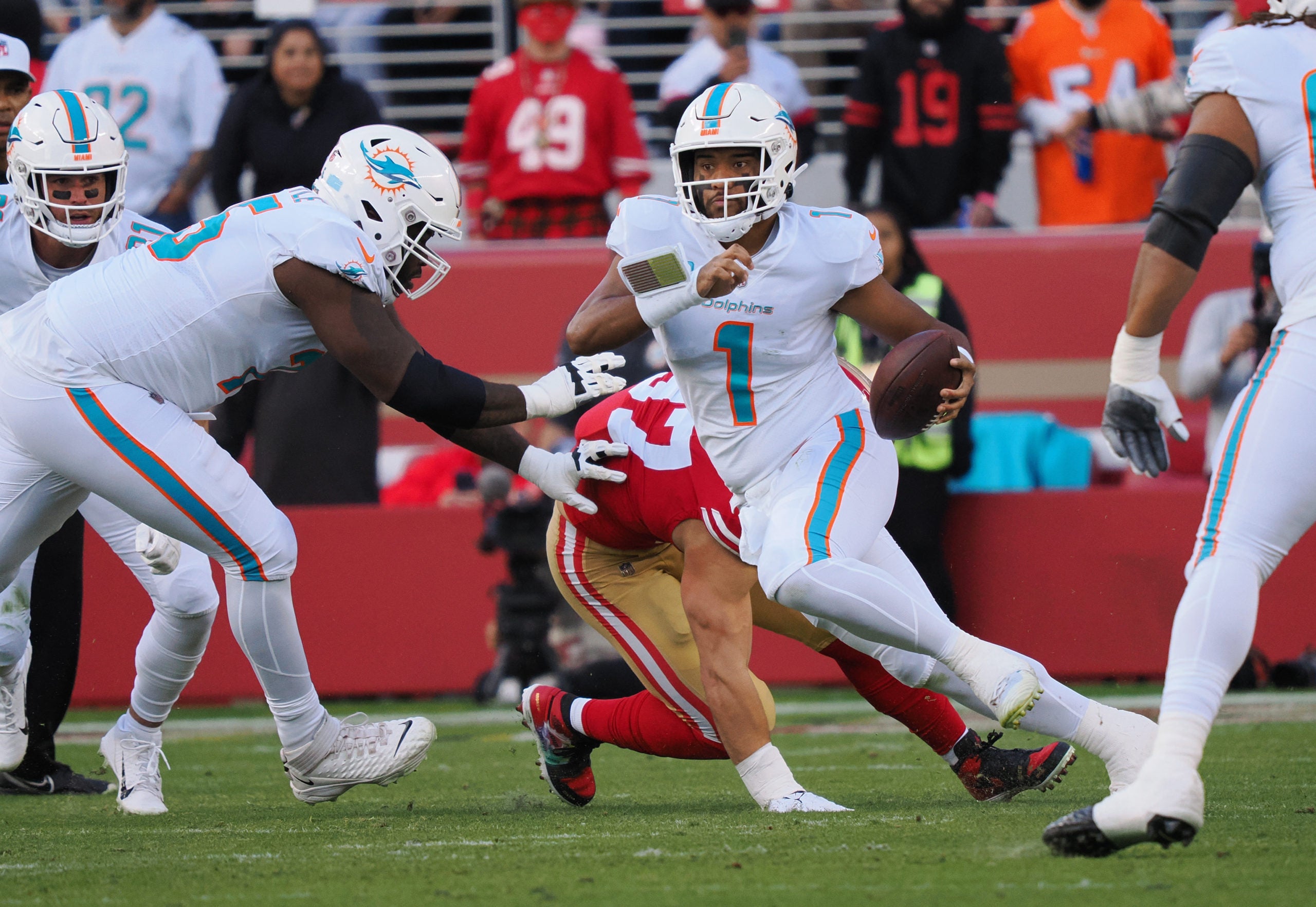 Dec 4, 2022; Santa Clara, California, USA; Miami Dolphins quarterback Tua Tagovailoa (1) escapes San Francisco 49ers defensive end Nick Bosa (97) during the first quarter at Levi's Stadium. Mandatory Credit: Kelley L Cox-USA TODAY Sports