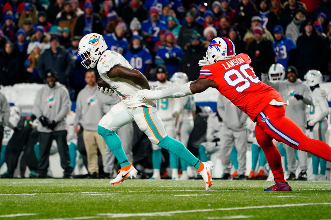 Dec 17, 2022; Orchard Park, New York, USA; Miami Dolphins running back Raheem Mostert (31) runs with the ball against Buffalo Bills defensive end Shaq Lawson (90) during the first half at Highmark Stadium. Mandatory Credit: Gregory Fisher-USA TODAY Sports