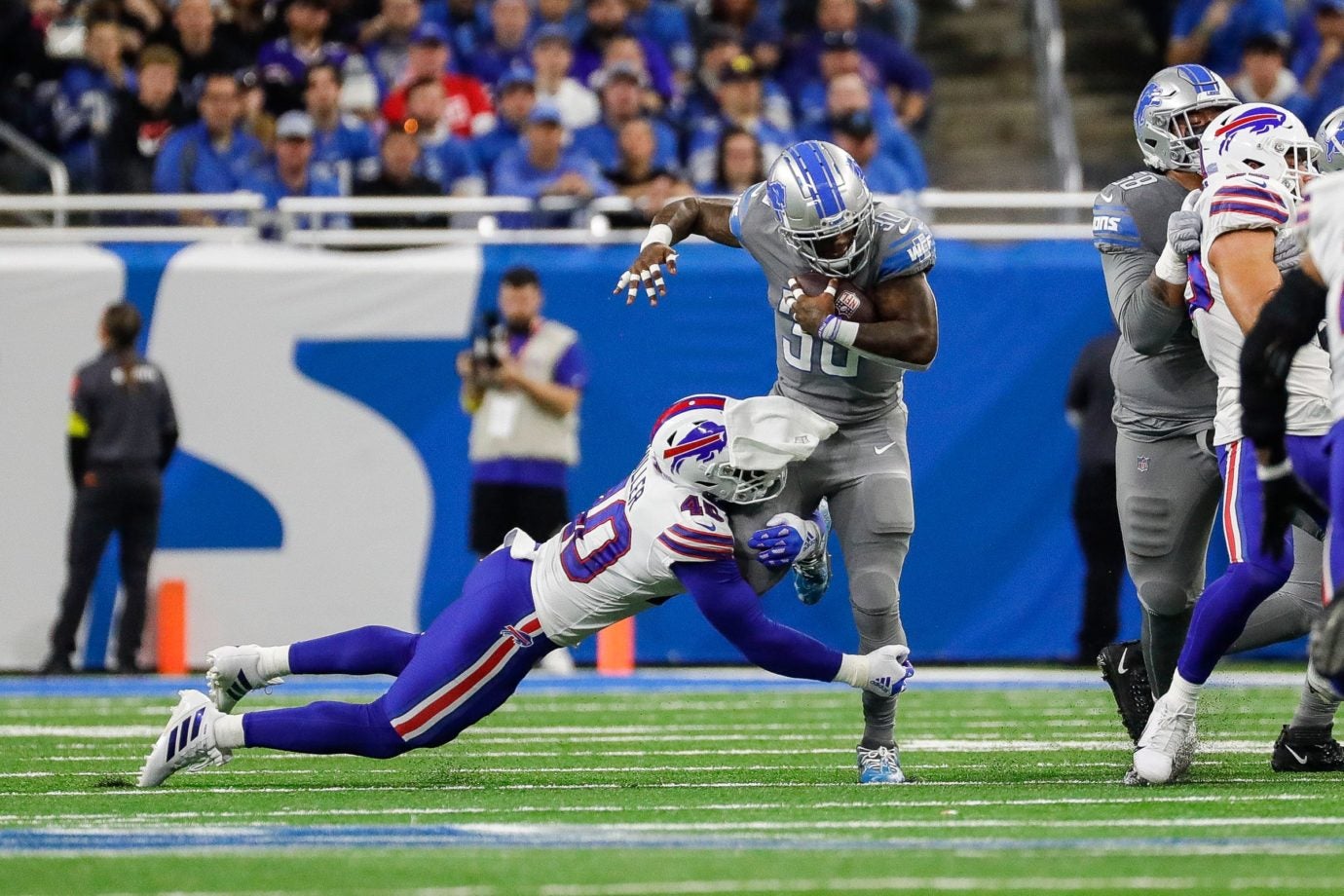 Detroit Lions running back Jamaal Williams (30) runs against Buffalo Bills linebacker Von Miller (40) during the first half at Ford Field in Detroit on Thursday, Nov. 24, 2022.