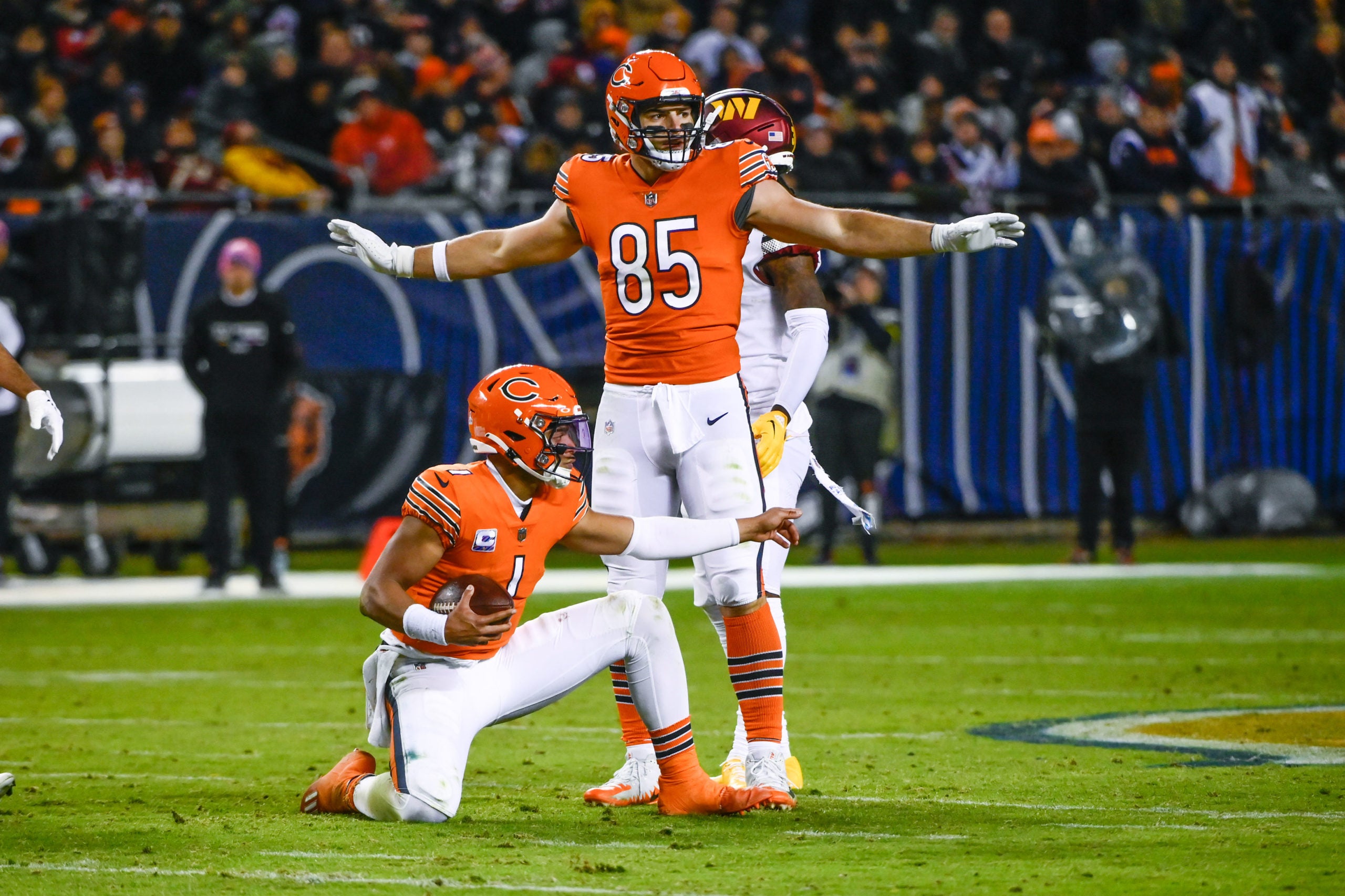 Oct 13, 2022; Chicago, Illinois, USA; Chicago Bears quarterback Justin Fields (1) after running with the ball against the Washington Commanders as Chicago Bears tight end Cole Kmet (85) looks on during the second half at Soldier Field. Mandatory Credit: Matt Marton-USA TODAY Sports