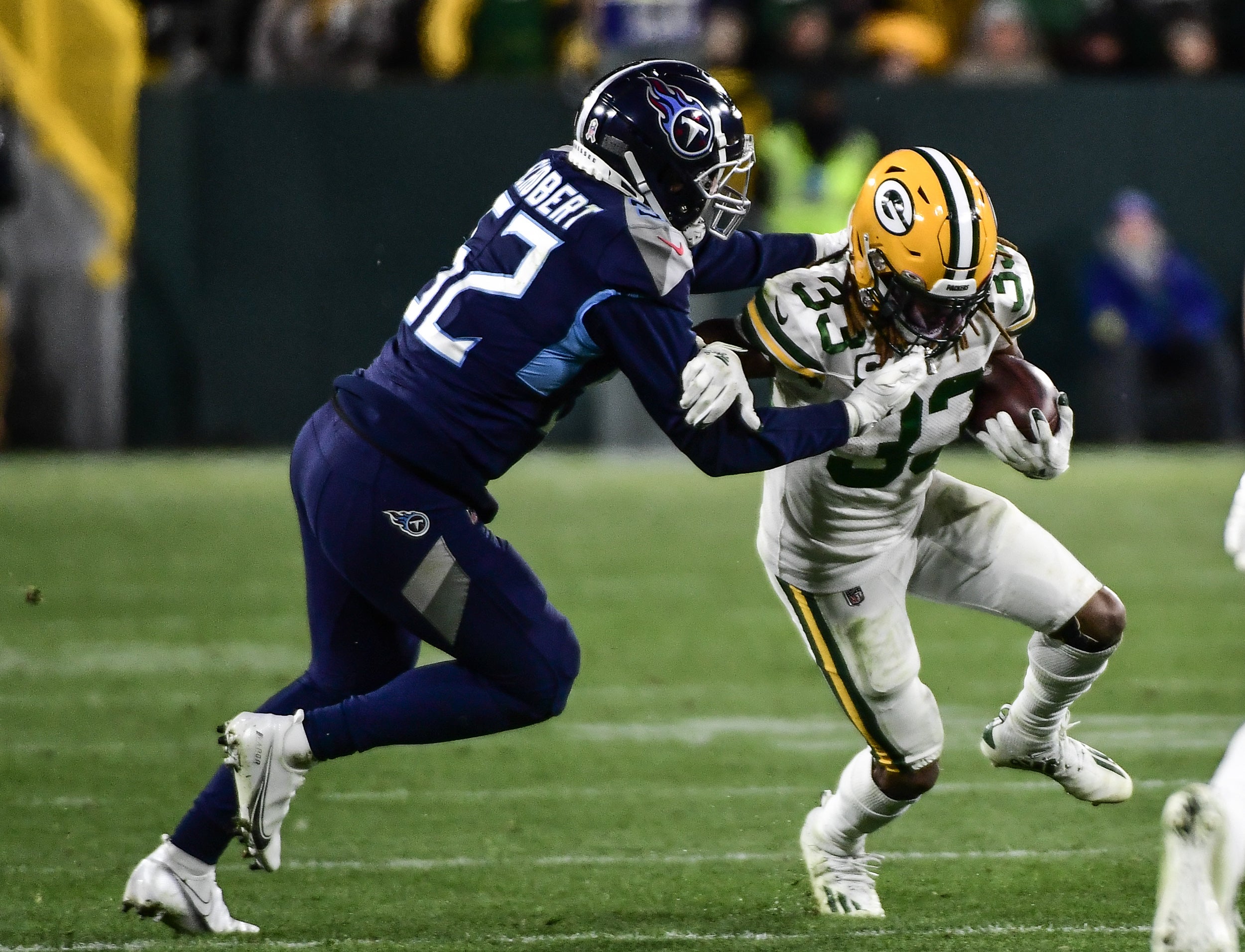 Nov 17, 2022; Green Bay, Wisconsin, USA; Green Bay Packers running back Aaron Jones (33) is tackled by Tennessee Titans linebacker Joe Schobert (52) in the fourth quarter at Lambeau Field. Mandatory Credit: Benny Sieu-USA TODAY Sports