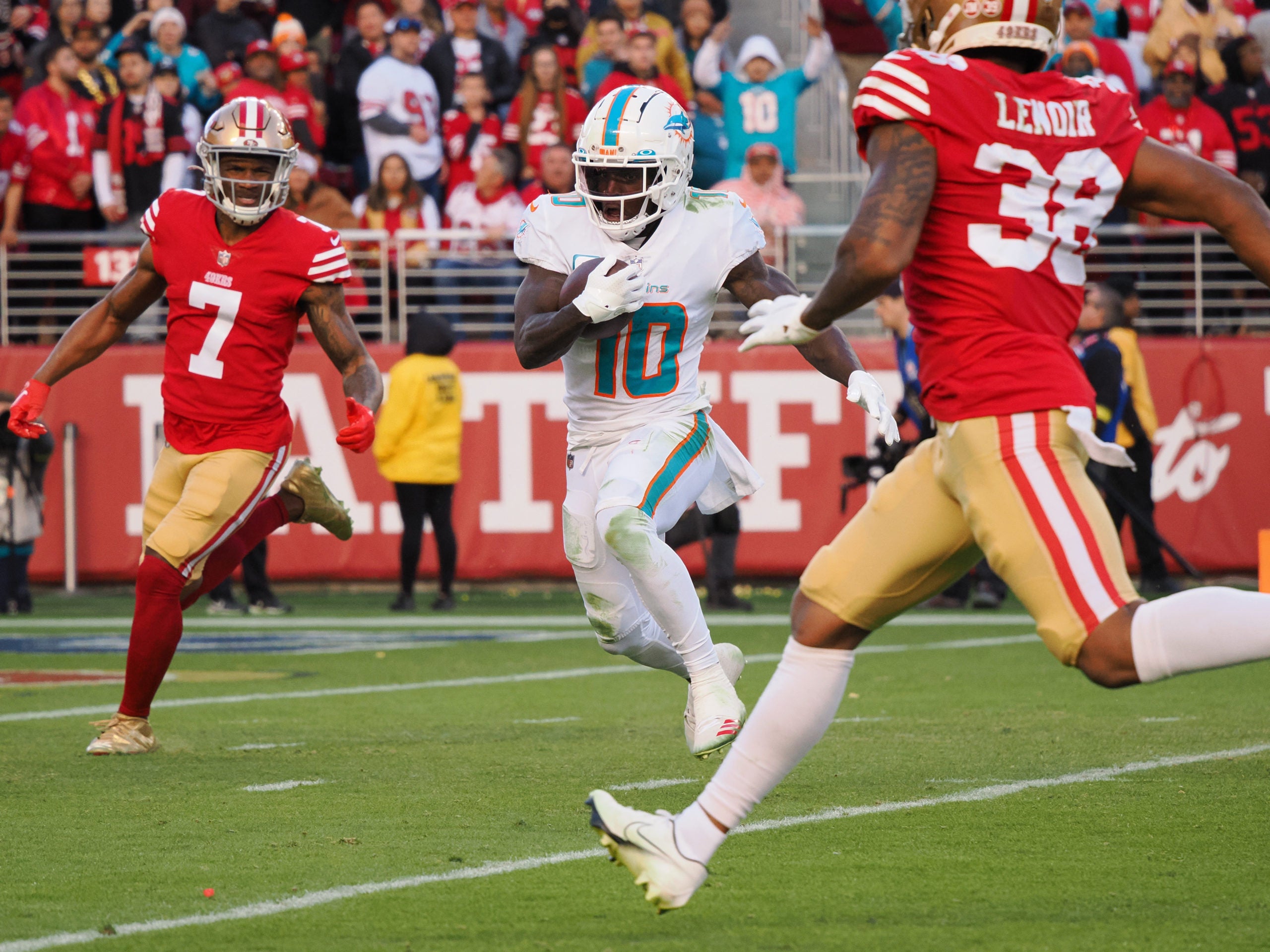 Dec 4, 2022; Santa Clara, California, USA; Miami Dolphins wide receiver Tyreek Hill (10) controls the ball for a touchdown between San Francisco 49ers cornerback Chavarius War (7) and cornerback Deommodore Lenoir (38) during the fourth quarter at Levi's Stadium. Mandatory Credit: Kelley L Cox-USA TODAY Sports