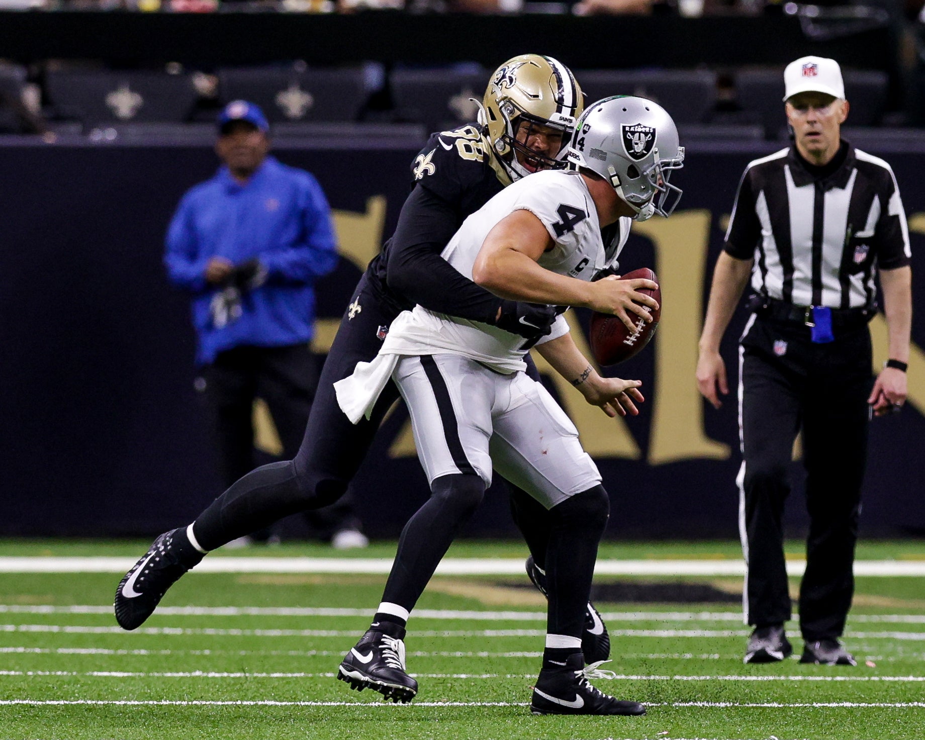 Oct 30, 2022; New Orleans, Louisiana, USA;  Las Vegas Raiders quarterback Derek Carr (4) is sacked by New Orleans Saints defensive end Payton Turner (98) during the second half at Caesars Superdome. Mandatory Credit: Stephen Lew-USA TODAY Sports