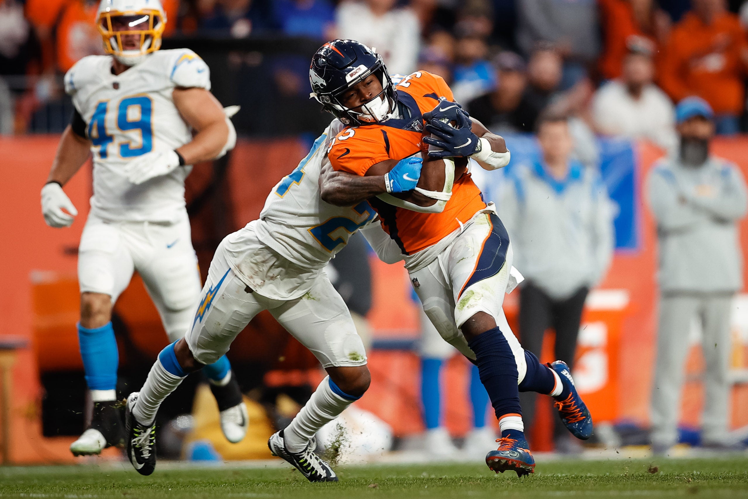 Nov 28, 2021; Denver, Colorado, USA; Denver Broncos running back Javonte Williams (33) runs the ball under pressure from Los Angeles Chargers safety Nasir Adderley (24) in the fourth quarter at Empower Field at Mile High. Mandatory Credit: Isaiah J. Downing-USA TODAY Sports