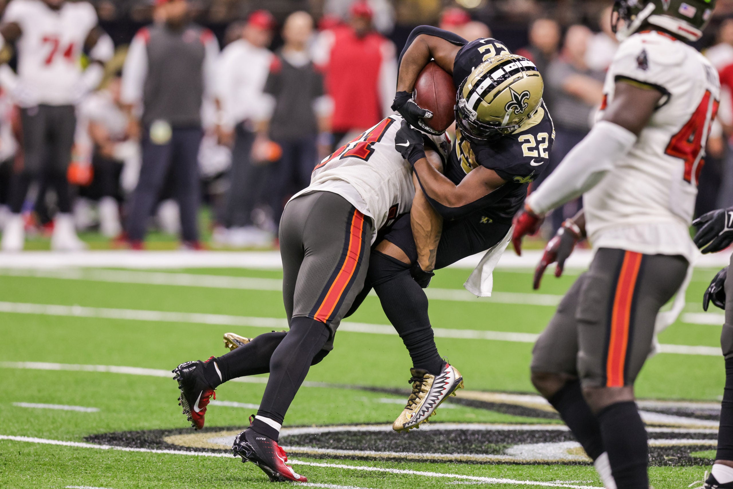 Sep 18, 2022; New Orleans, Louisiana, USA;  New Orleans Saints running back Mark Ingram II (22) is tackled by Tampa Bay Buccaneers safety Antoine Winfield Jr. (31) and cornerback Carlton Davis III (24) during the second half at Caesars Superdome. Mandatory Credit: Stephen Lew-USA TODAY Sports