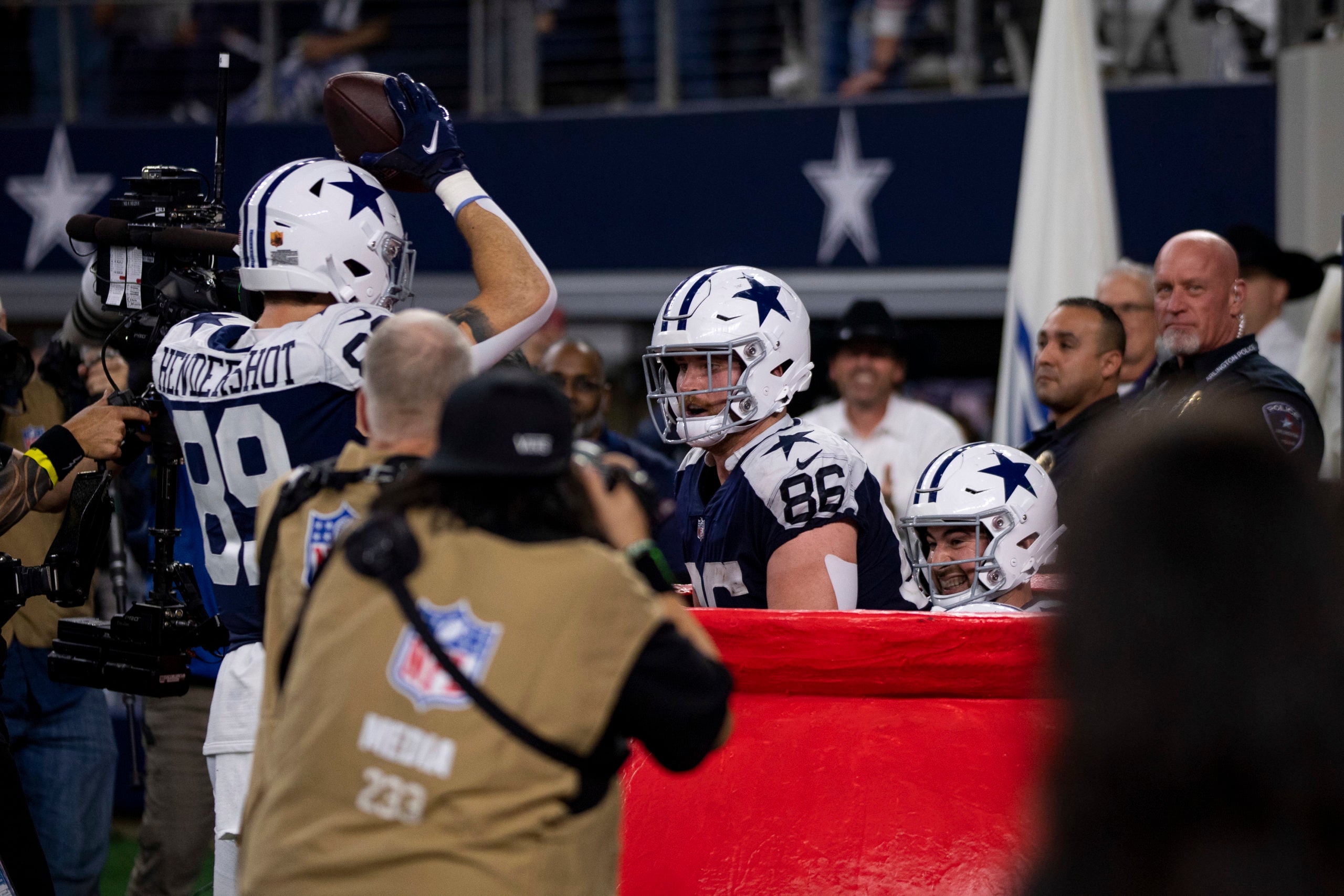 Nov 24, 2022; Arlington, Texas, USA; Dallas Cowboys tight end Sean McKeon (84) and tight end Peyton Hendershot (89) and tight end Dalton Schultz (86) celebrates a touchdown against the New York Giants by jumping in the Salvation Army Kettle during the second half of the game between the Cowboys and the Giants at AT&T Stadium. Mandatory Credit: Jerome Miron-USA TODAY Sports