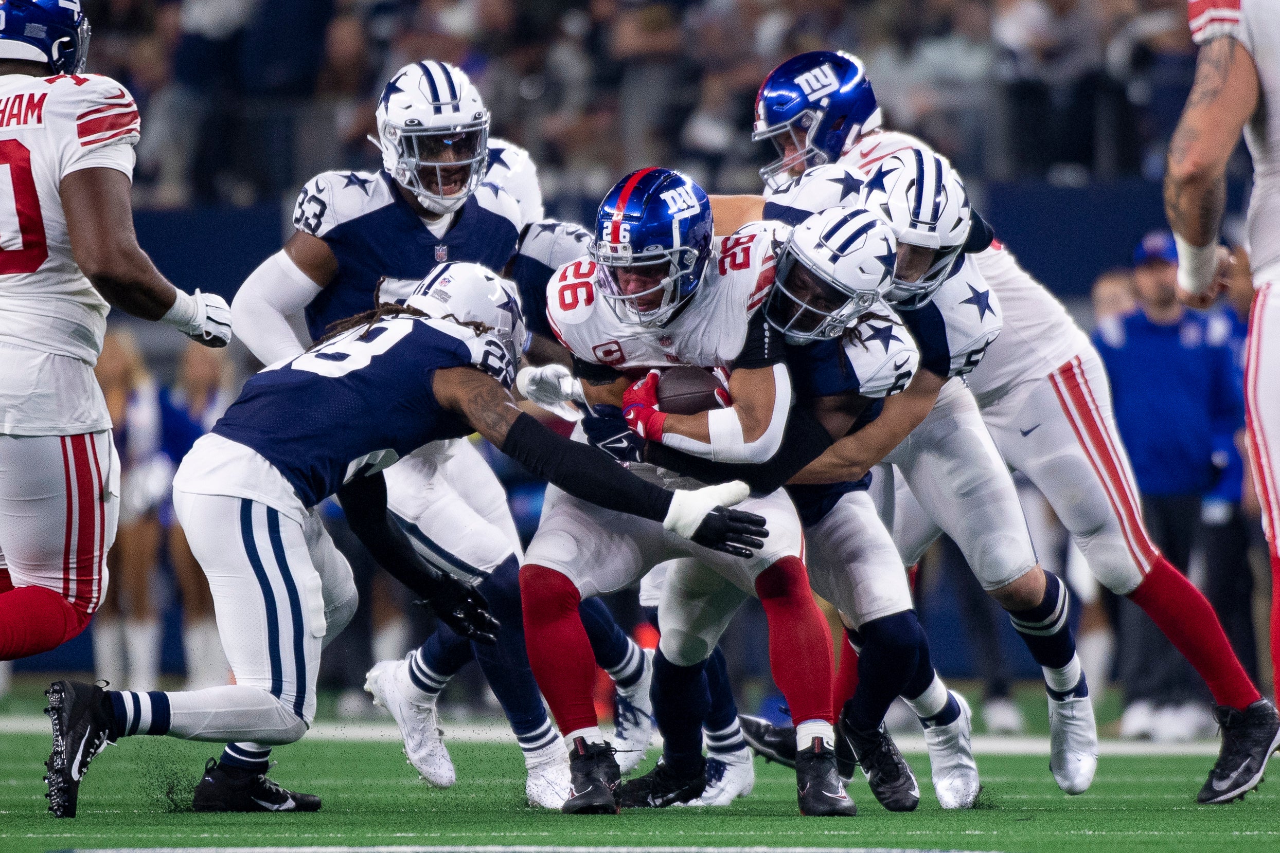Nov 24, 2022; Arlington, Texas, USA; New York Giants running back Saquon Barkley (26) is tackled by the Dallas Cowboys defense during the second half of the game between the Cowboys and the Giants at AT&T Stadium. Mandatory Credit: Jerome Miron-USA TODAY Sports