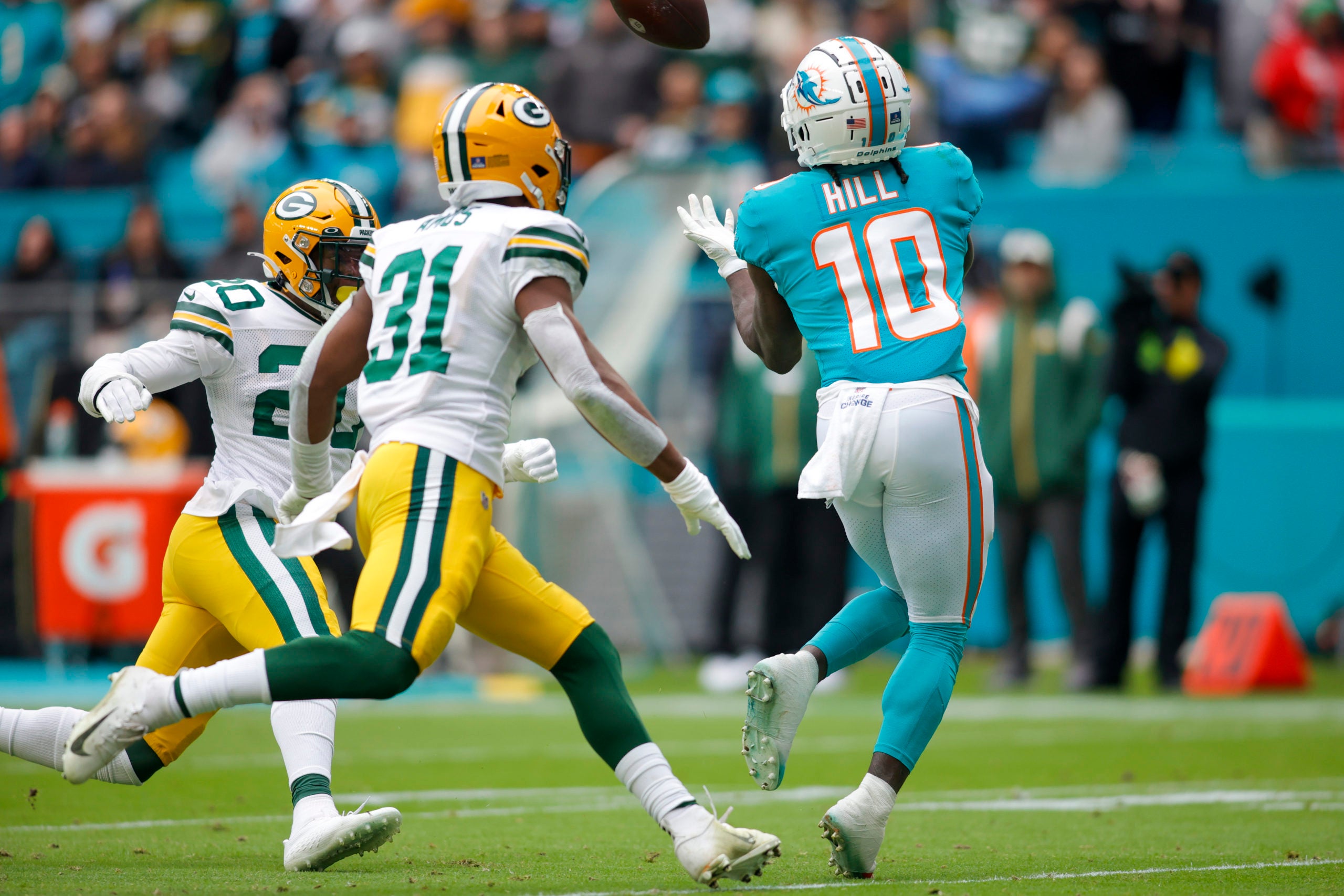 Dec 25, 2022; Miami Gardens, Florida, USA; Miami Dolphins wide receiver Tyreek Hill (10) catches the football ahead of Green Bay Packers safety Rudy Ford (20) and safety Adrian Amos (31) during the second quarter at Hard Rock Stadium. Mandatory Credit: Sam Navarro-USA TODAY Sports